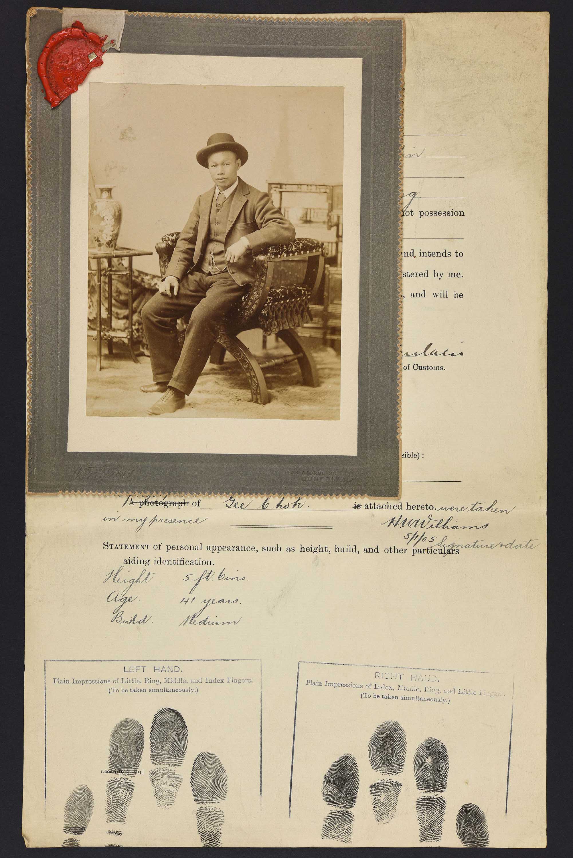 Sepia photo portrait of a Chinese man seated pinned to immigration papers
