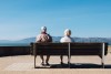 A senior couple sitting on a park bench.