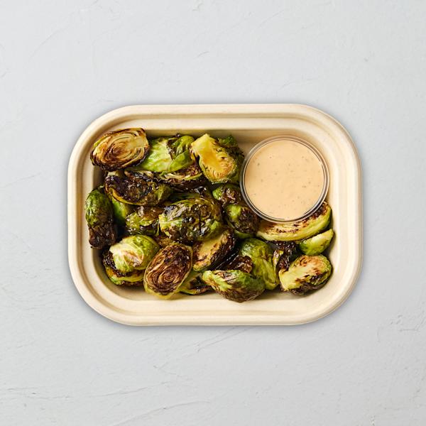 Sweetgreen maple-glazed roasted Brussels sprouts with a side of dipping sauce.