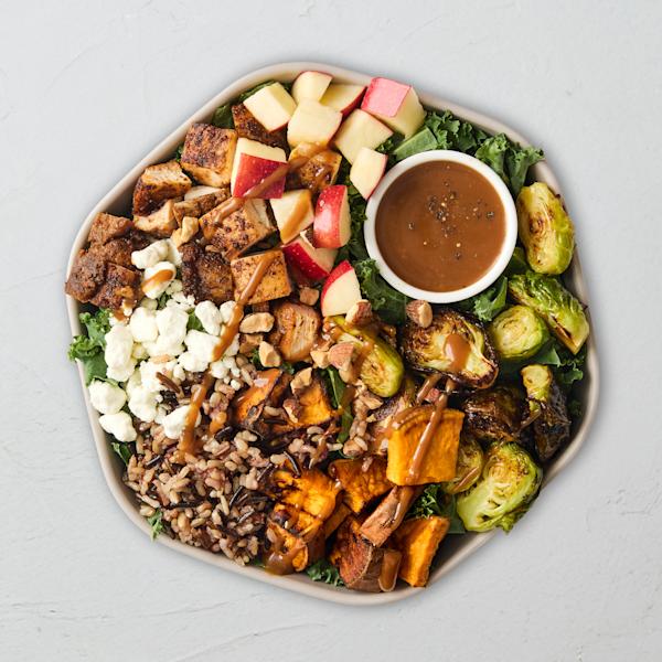 Sweetgreen Autumn Harvest Bowl with blackened chicken, kale, wild rice, sweet potato, Brussels sprouts, apples, goat cheese, and balsamic dressing.