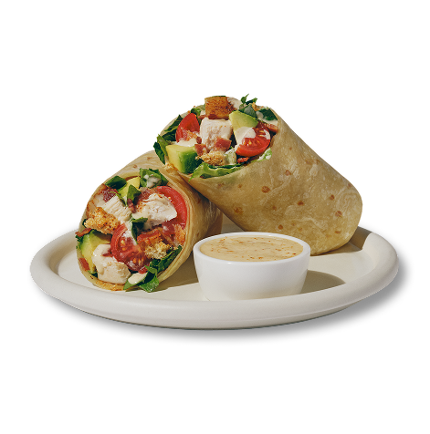 Cali Chicken Club Wrap on white plate with a side of dressing