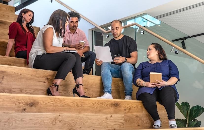 Employees sitting on stairs, collaborating