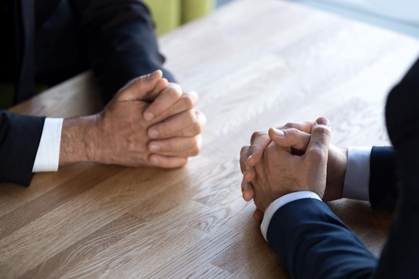 Two hands across a business table