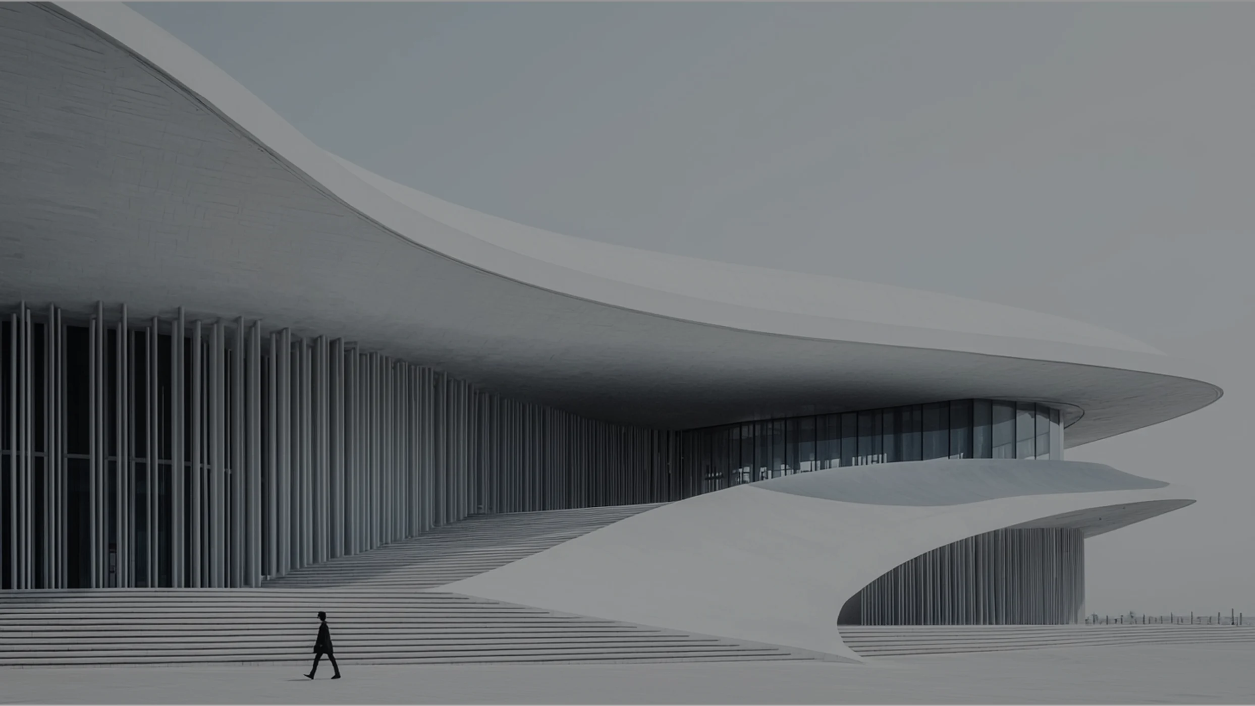 Exterior facade of a modern white opera house with sweeping curves and a figure walking up the steps.