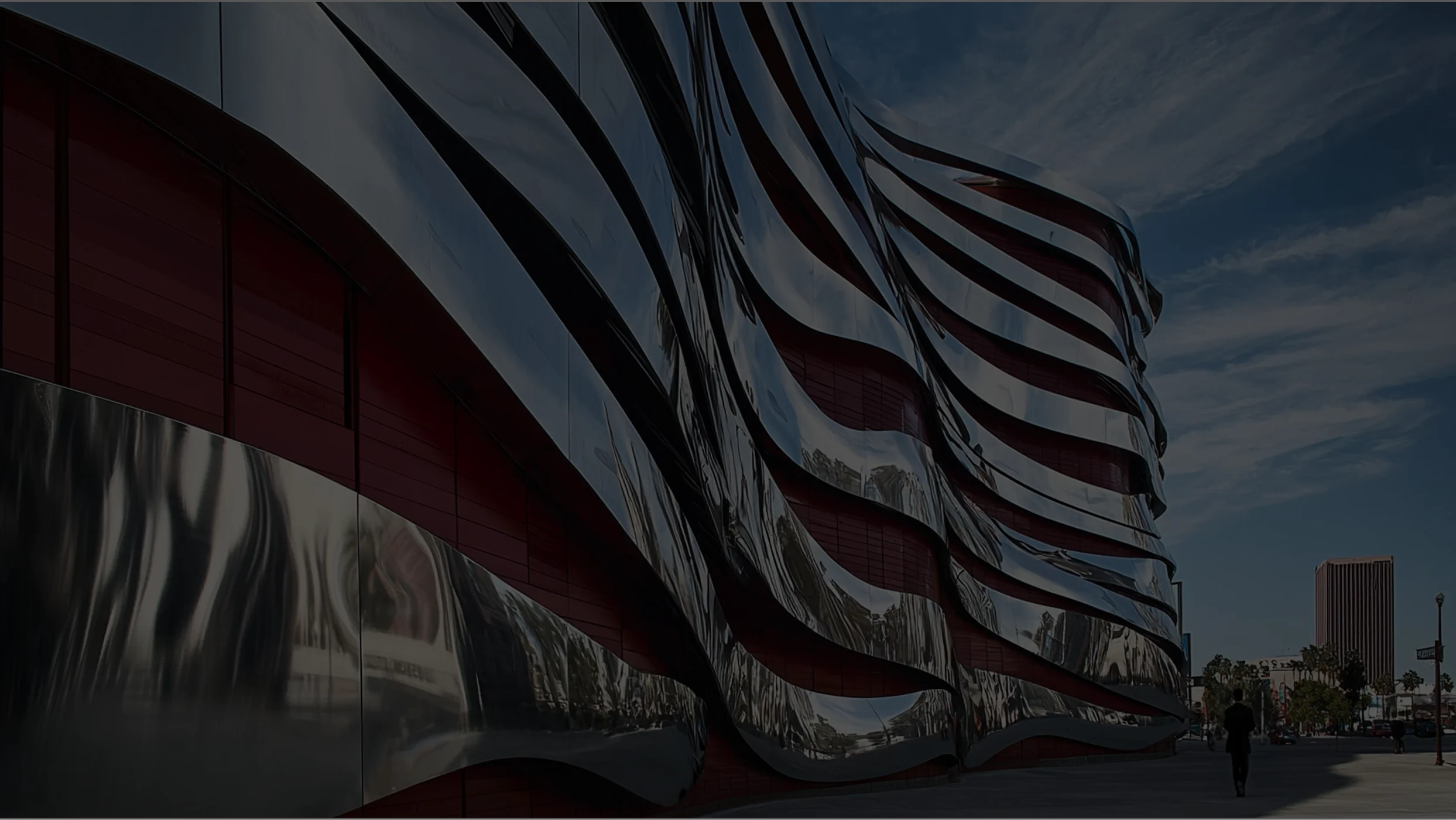 The Petersen Automotive Museum's iconic, undulating modern architecture, with polished steel panels and red walls.