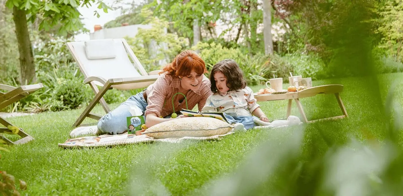 Une mère et sa fille assises sur la pelouse du jardin
