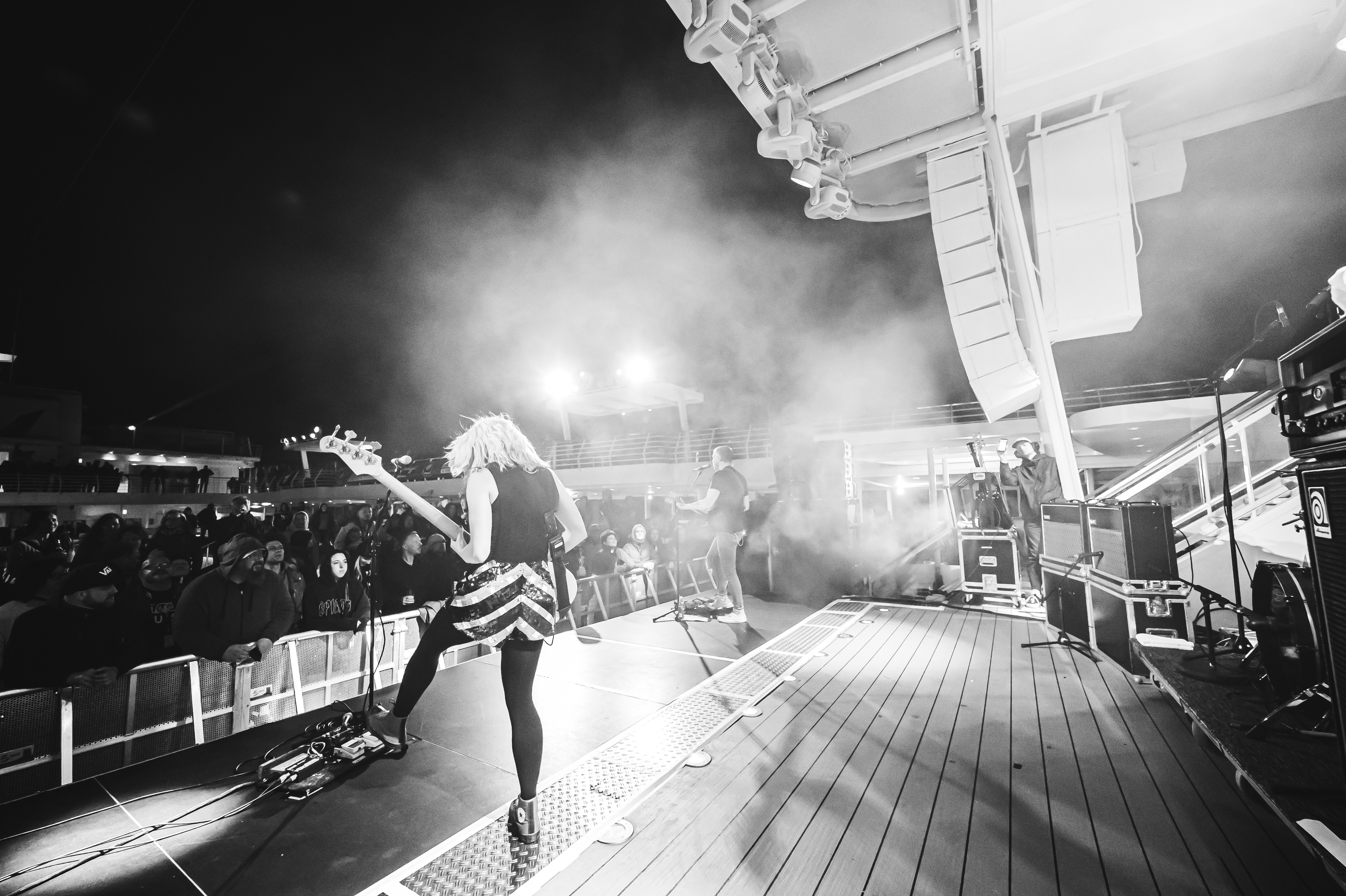 Musiker mit Gitarre singt auf Kreuzfahrtschiffbühne, Publikum klatscht.