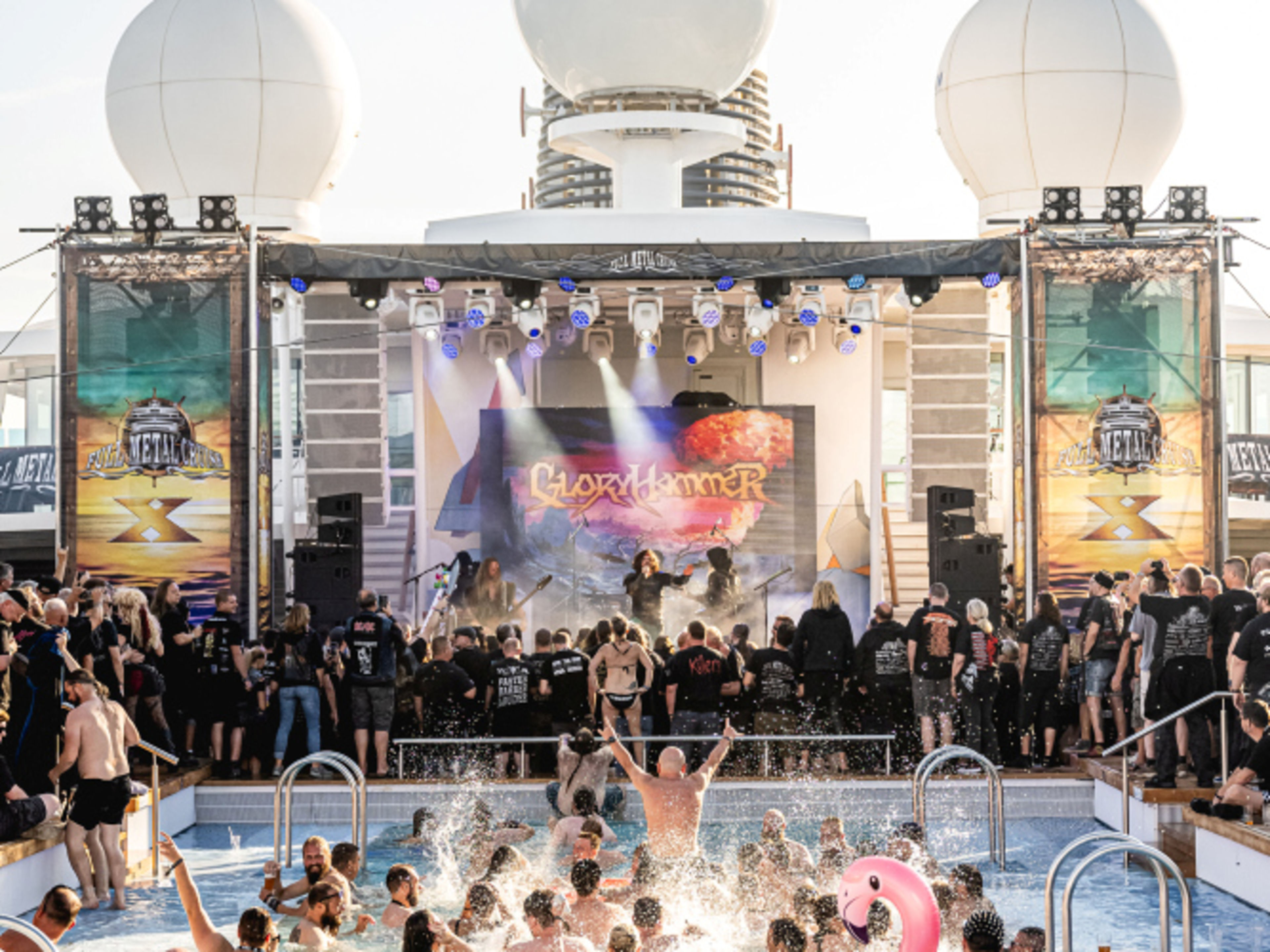 Poolparty mit Live-Band, Menschen planschen, pinker Flamingo-Schwimmring, Bühne mit Lichtshow Poolparty mit Live-Band, Menschen planschen, pinker Flamingo-Schwimmring, Bühne mit Lichtshow