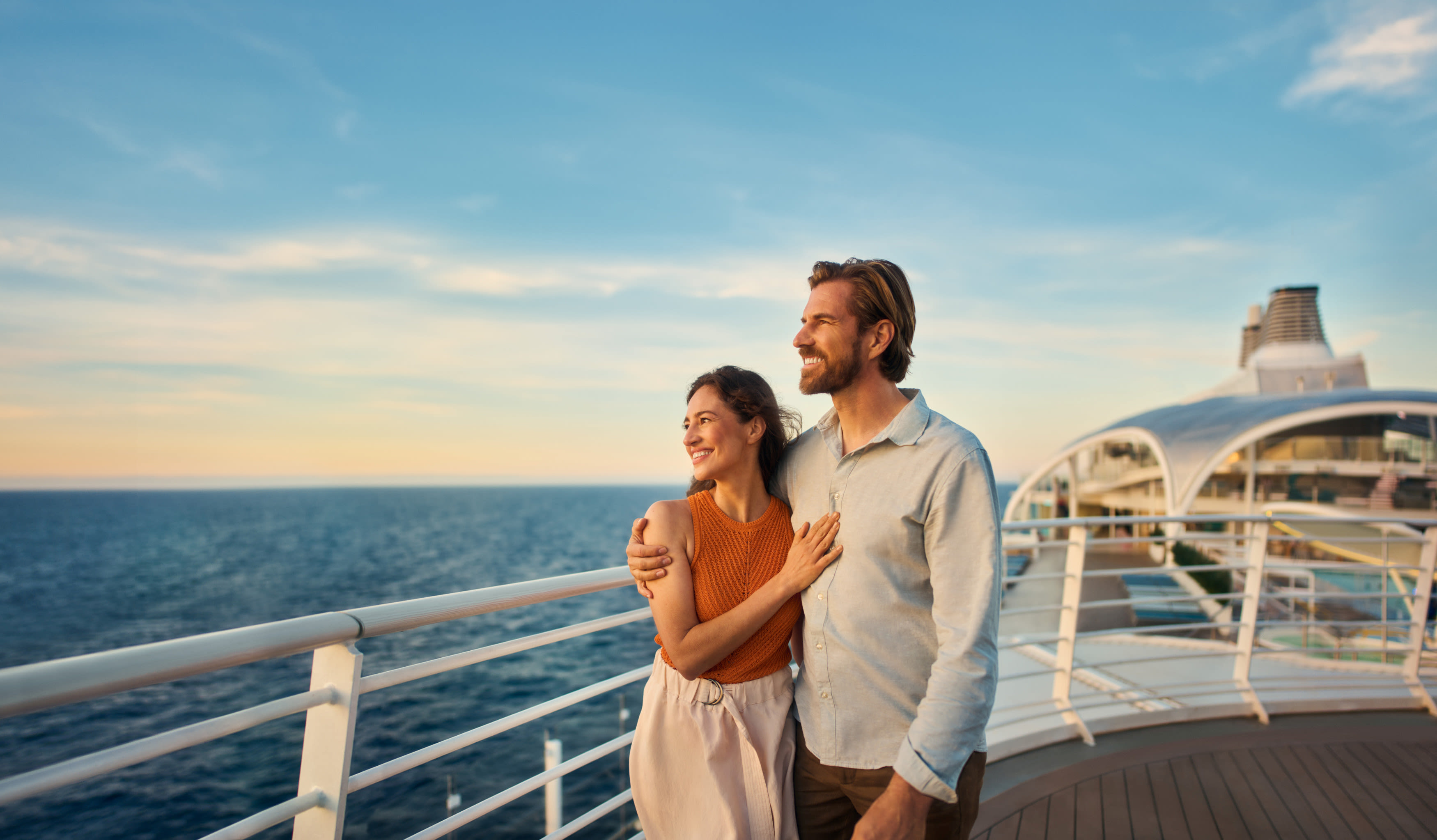 Paar auf dem Deck Paar genießt Sonnenuntergang auf Kreuzfahrtschiff der Mein Schiff® Flotte.