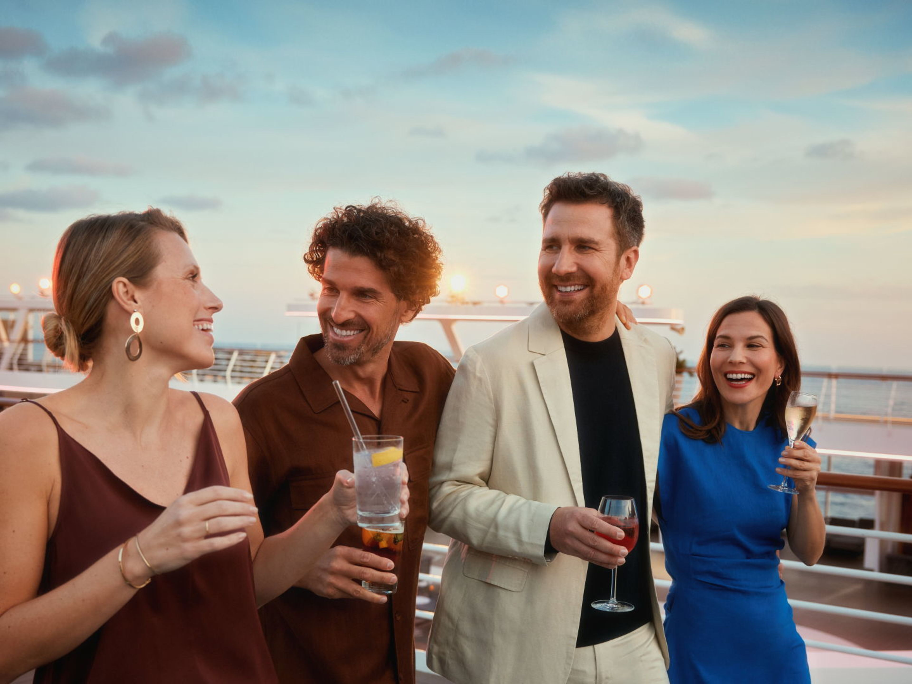 Vier Personen spazieren am frühen Abend auf einem Kreuzfahrtschiff der Mein Schiff® Flotte. Vier Personen spazieren am frühen Abend auf einem Kreuzfahrtschiff der Mein Schiff® Flotte.