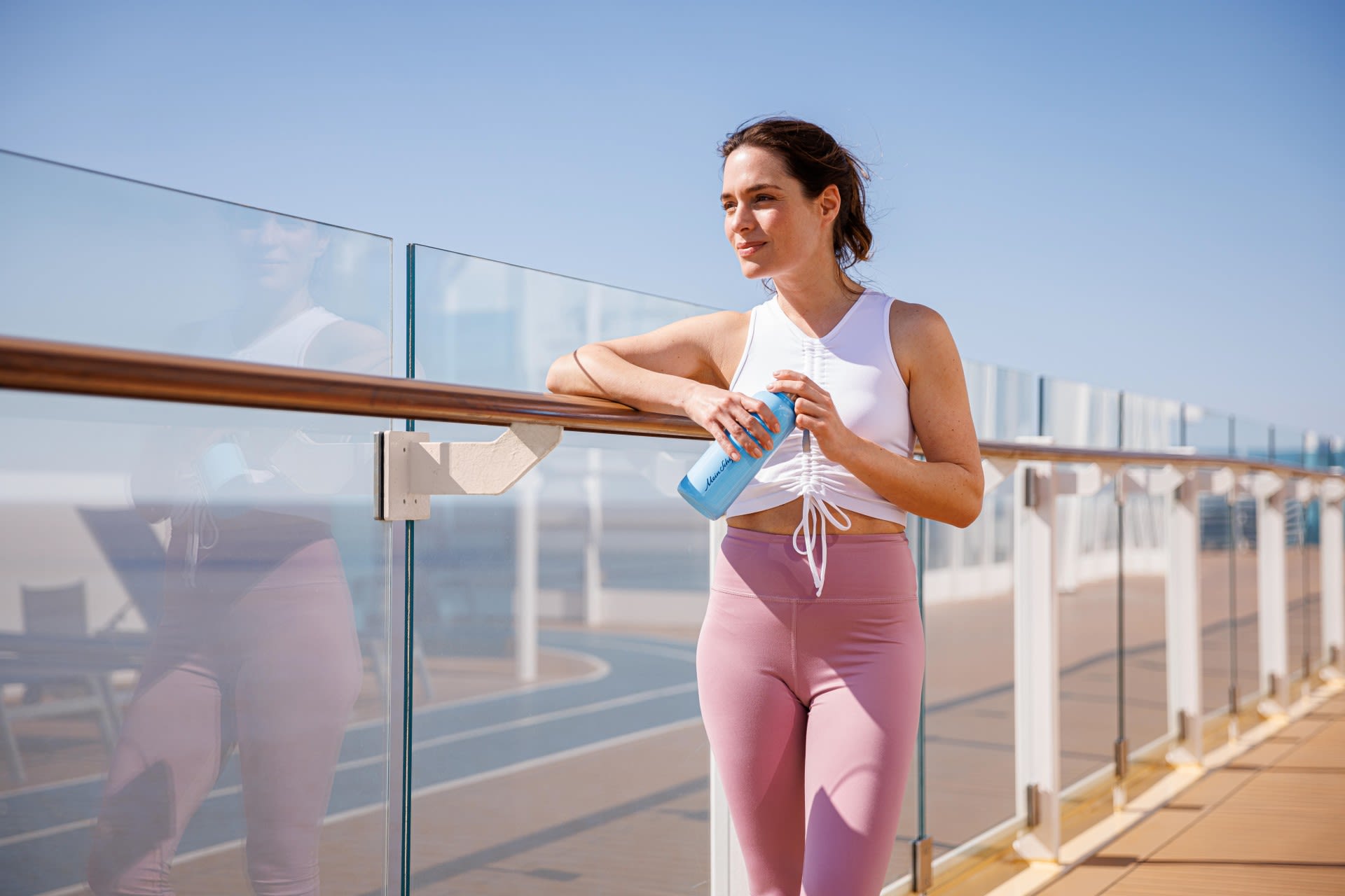 Mein Schiff Sport Reling Trinkflasche Frau in Sportkleidung mit Wasserflasche auf Kreuzfahrtschiff-Deck.