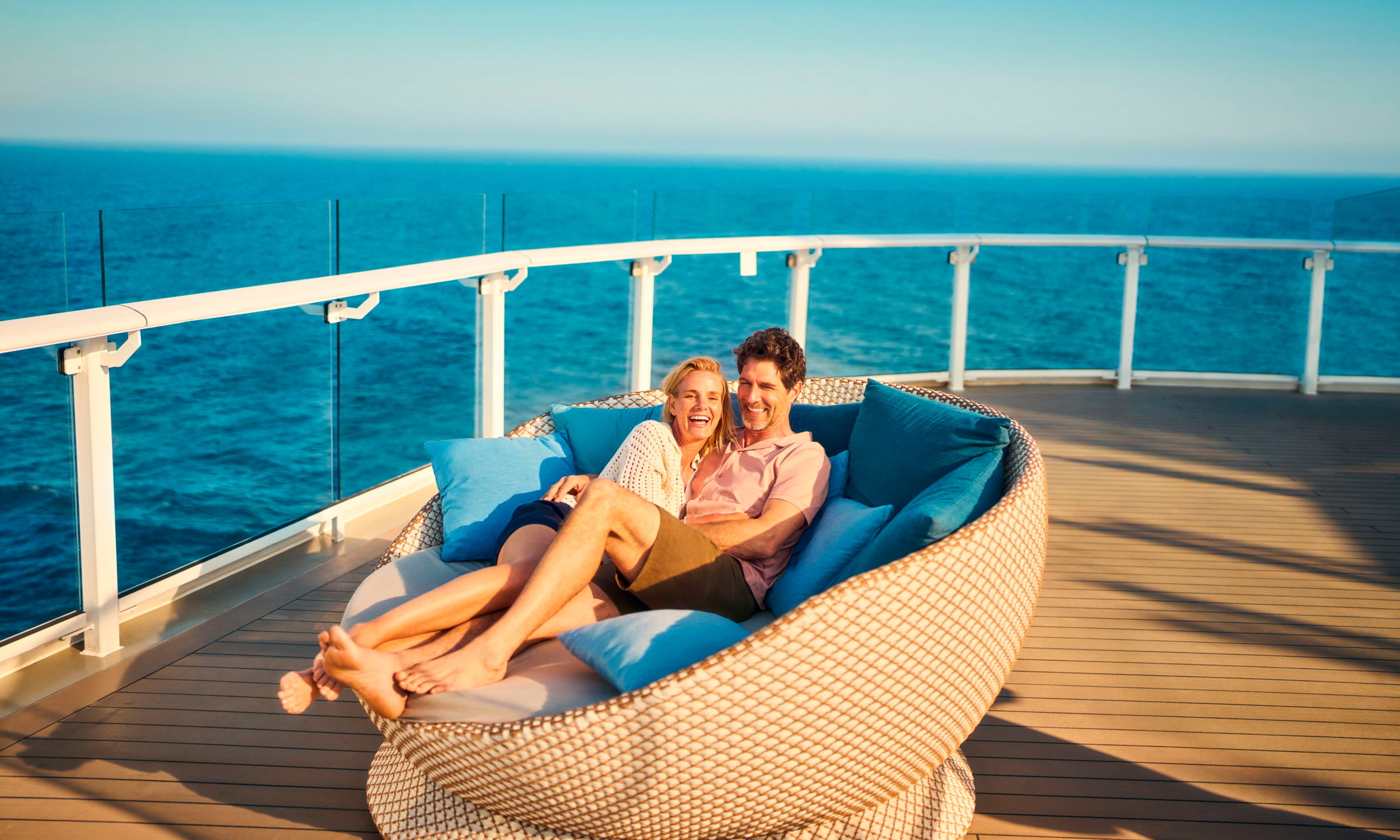 Paar kuschelt im Daybed Paar kuschelt im Daybed auf ihrer Flitterwochen Kreuzfahrt