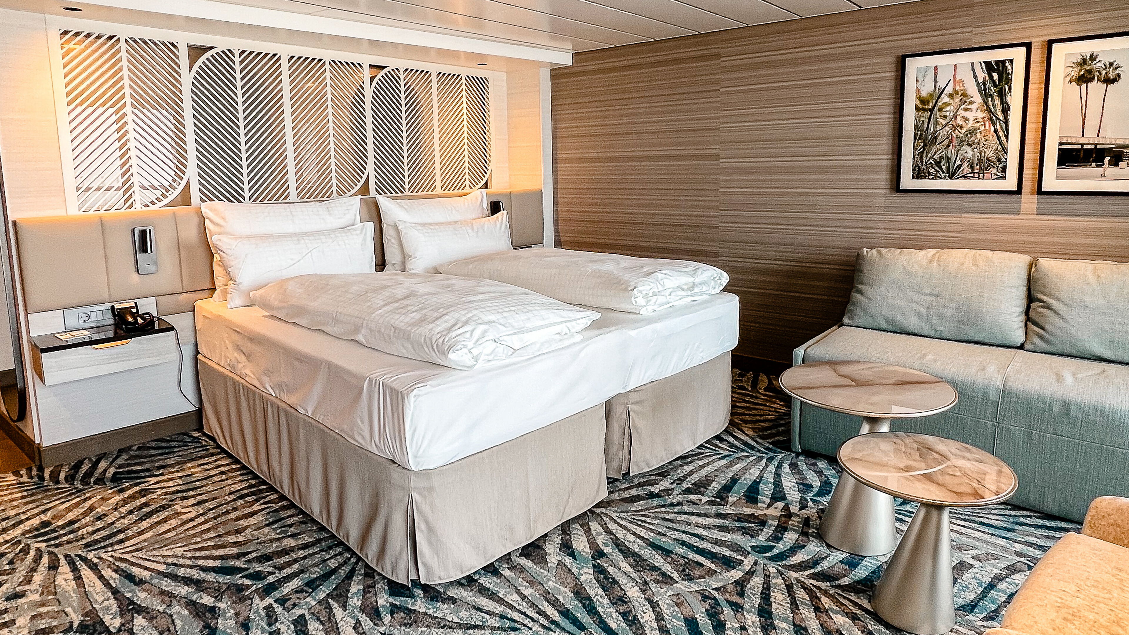 Schöne Aussicht Suite mit Doppelbett, Sofa und Kunstwerken an der Wand.