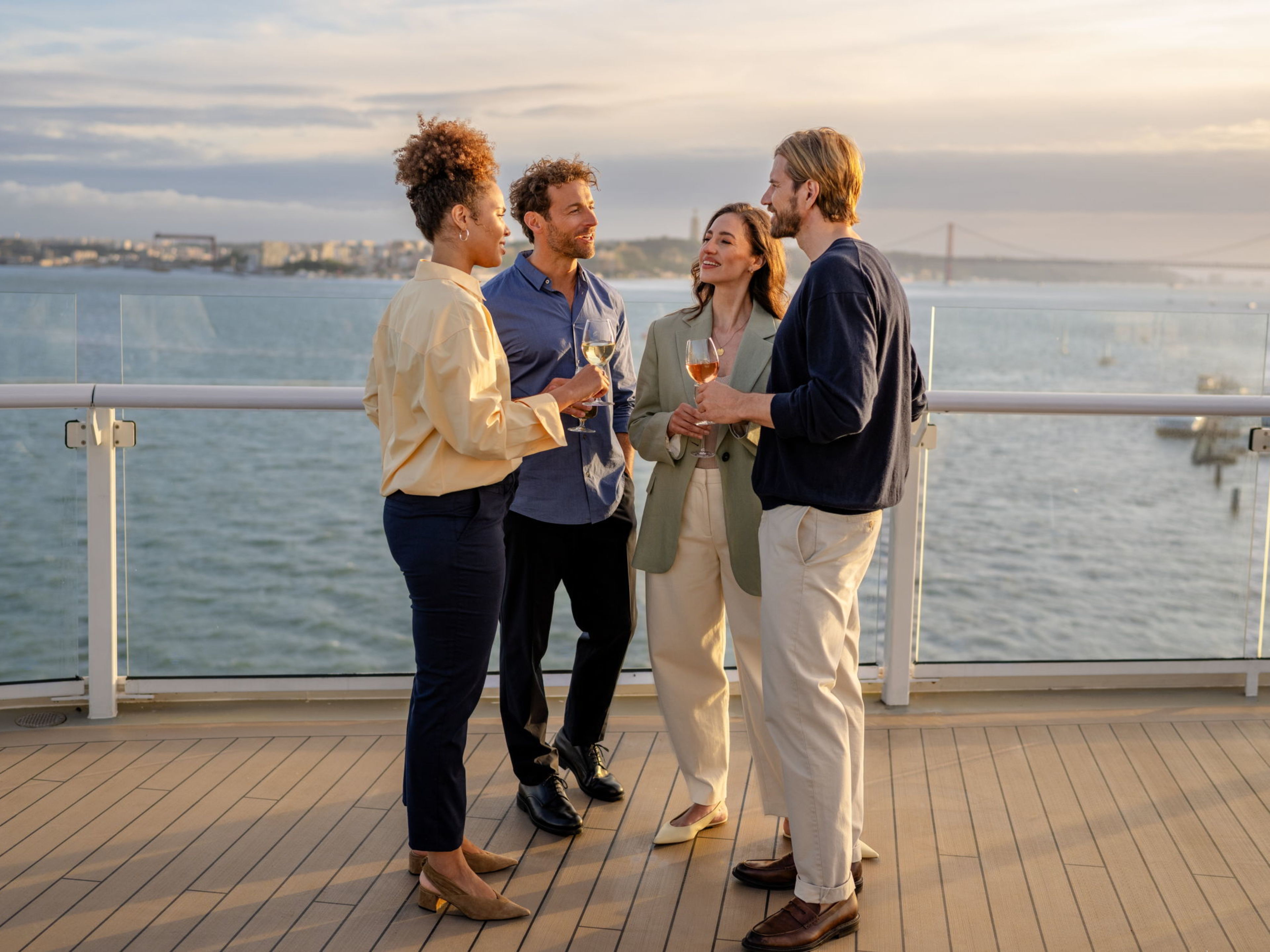 4 Personen unterhalten sich auf dem Außendeck 4 Personen unterhalten sich auf dem Außendeck
