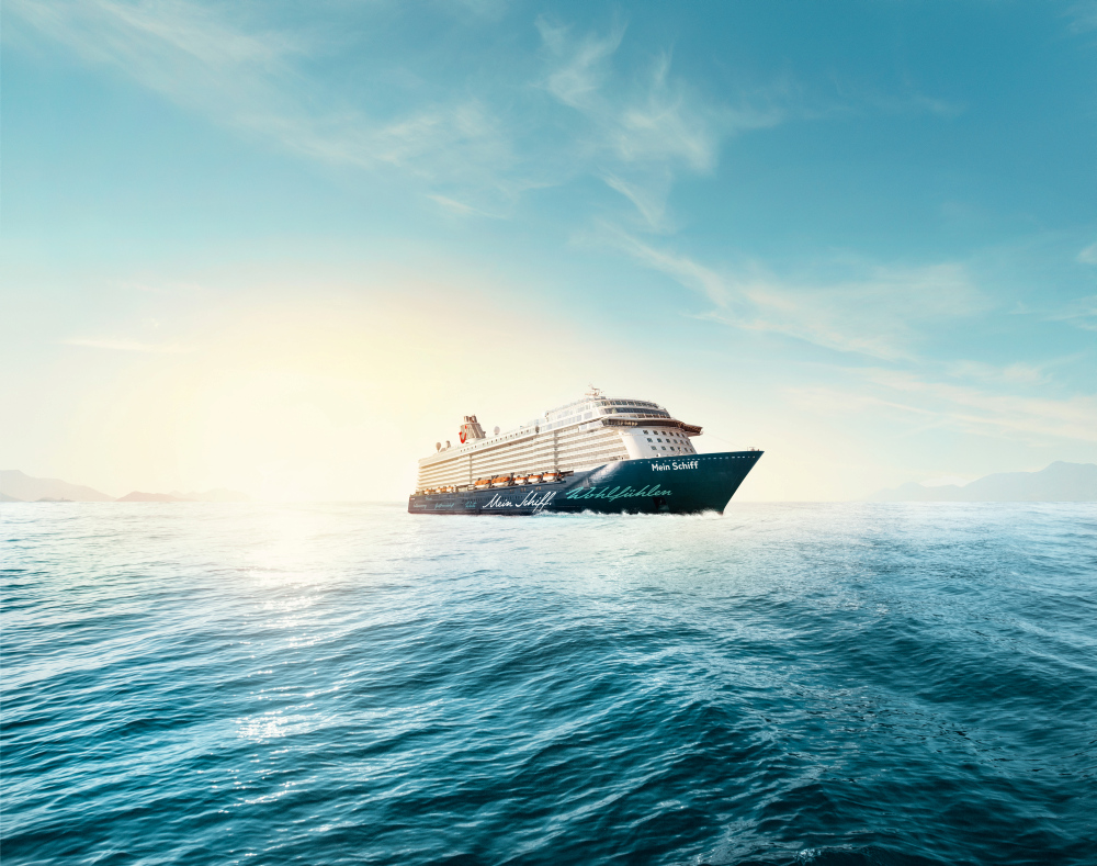 Kreuzfahrtschiff der Mein Schiff® Flotte auf offenem Meer bei Sonnenuntergang.