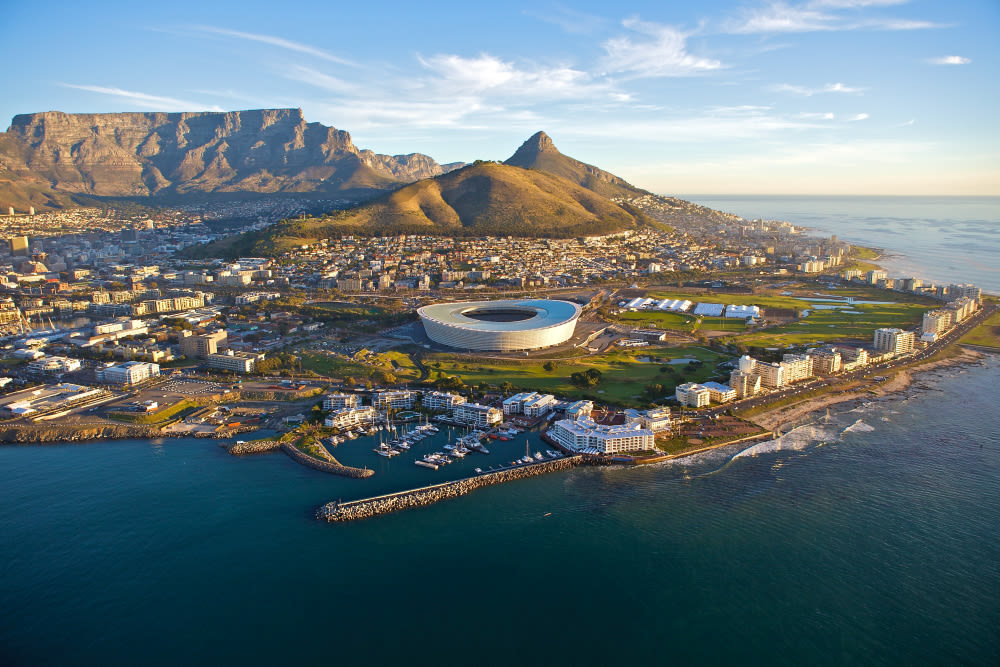 Kapstadt mit Tafelberg, Stadion und Küste bei Sonnenuntergang.