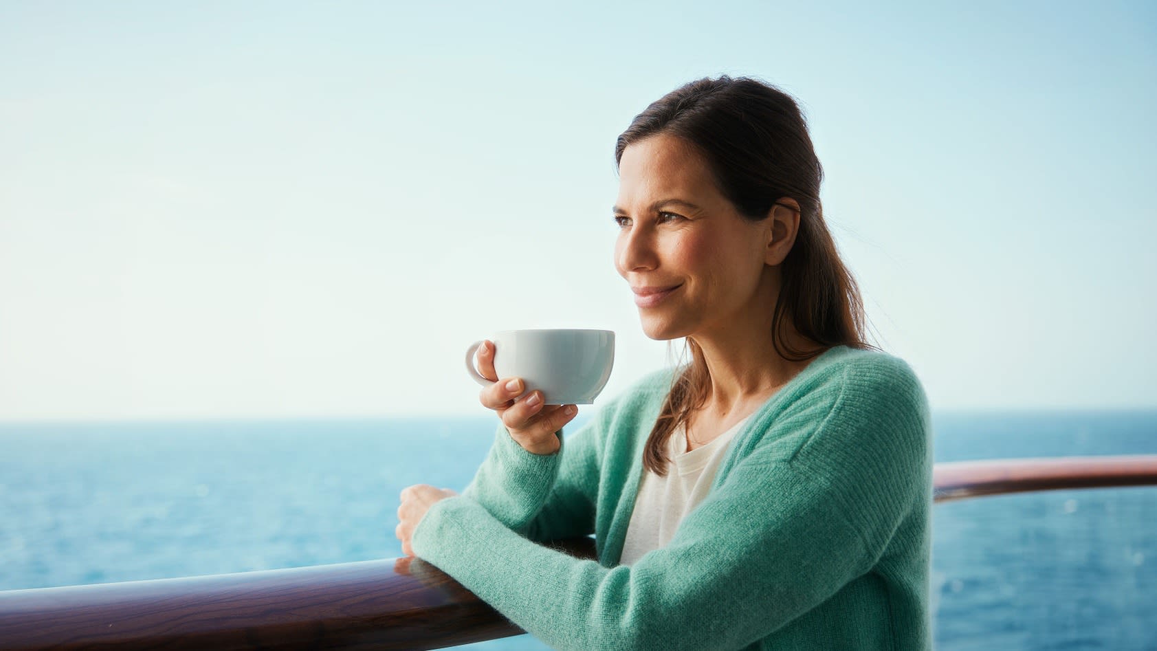 Frau genießt Kaffee auf Kreuzfahrtschiff, Meerblick. Frau genießt Kaffee auf Kreuzfahrtschiff, Meerblick.