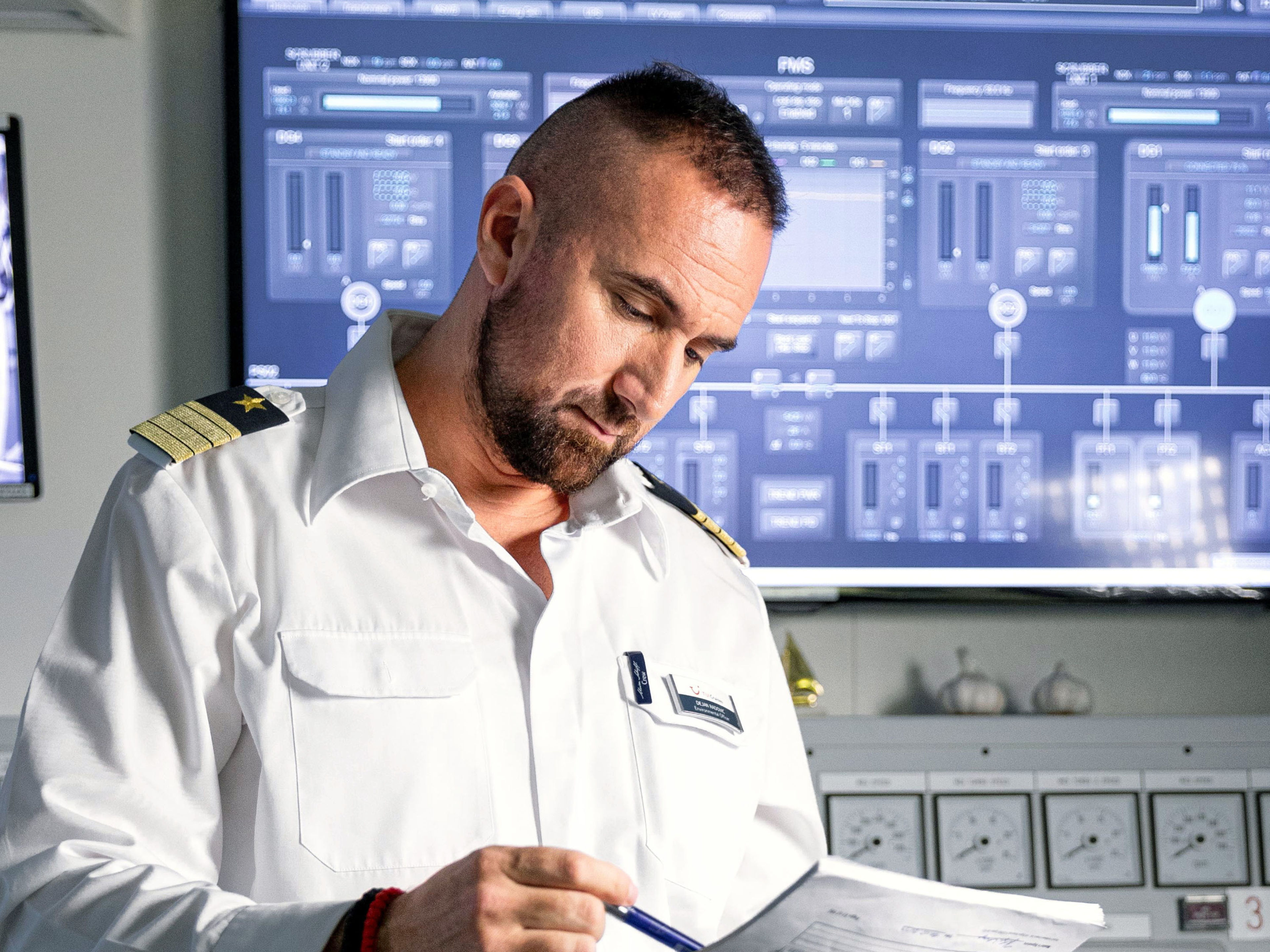 Nachhaltigkeit Umweltoffizier am Schreiben Mann in Uniform liest Dokumente vor Bildschirmen.