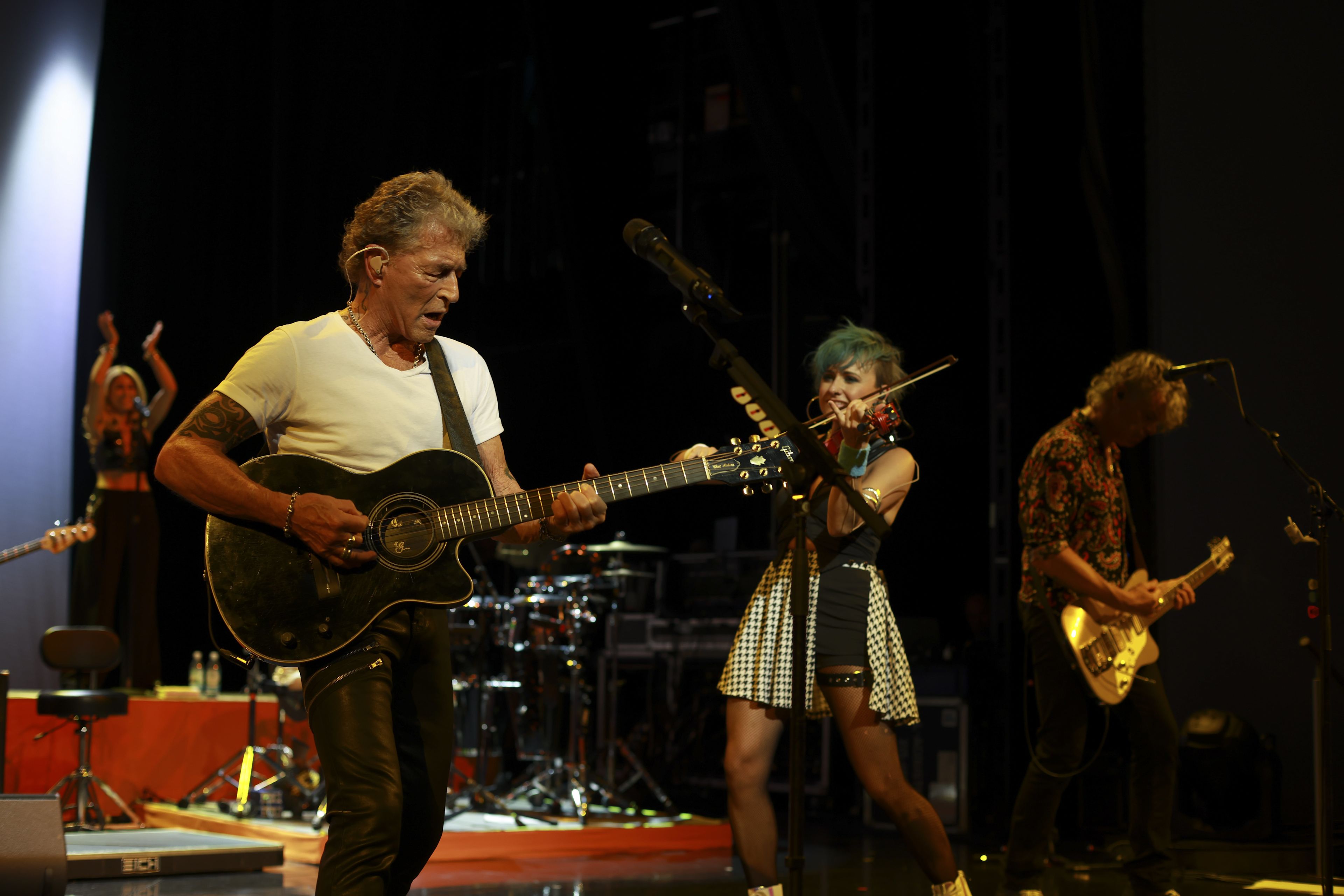 Musiker auf Bühne mit Gitarre und Geige, lebhafte Performance. Musiker auf Bühne mit Gitarre und Geige, lebhafte Performance.