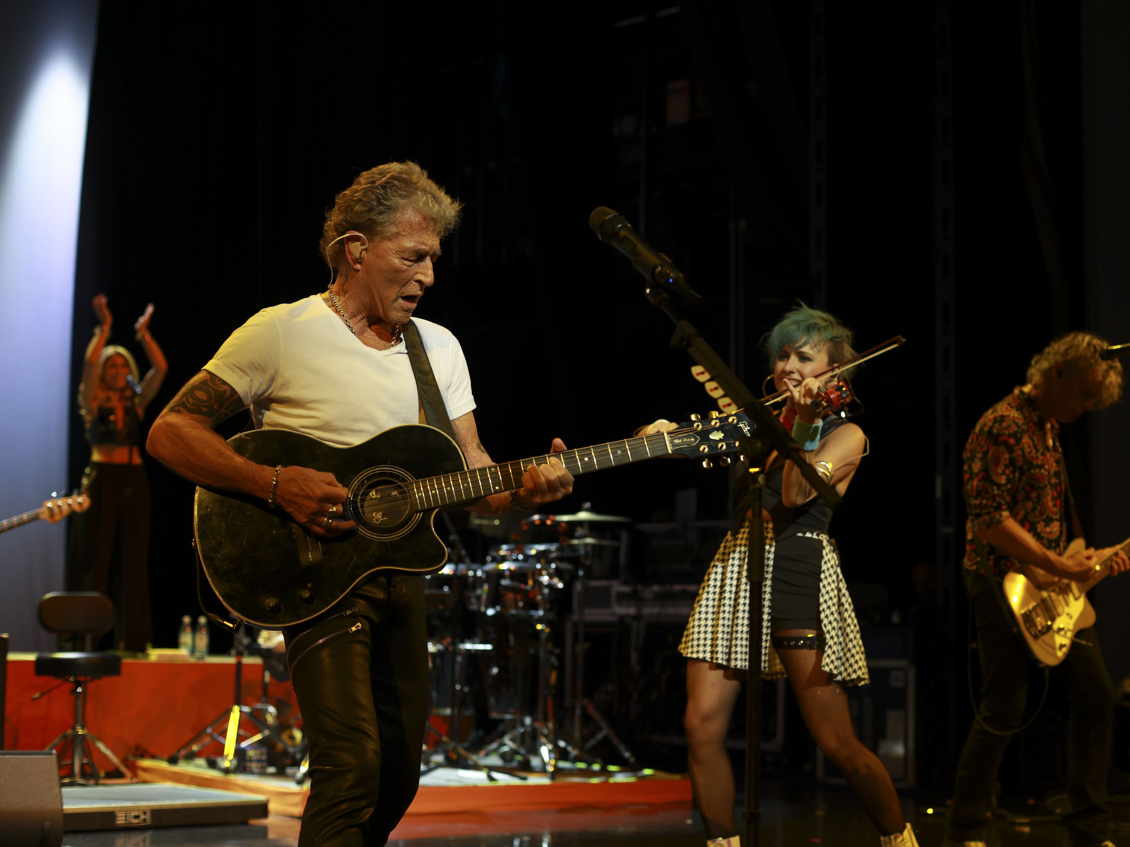 Peter Maffay Musiker auf Bühne mit Gitarre und Geige, lebhafte Performance.