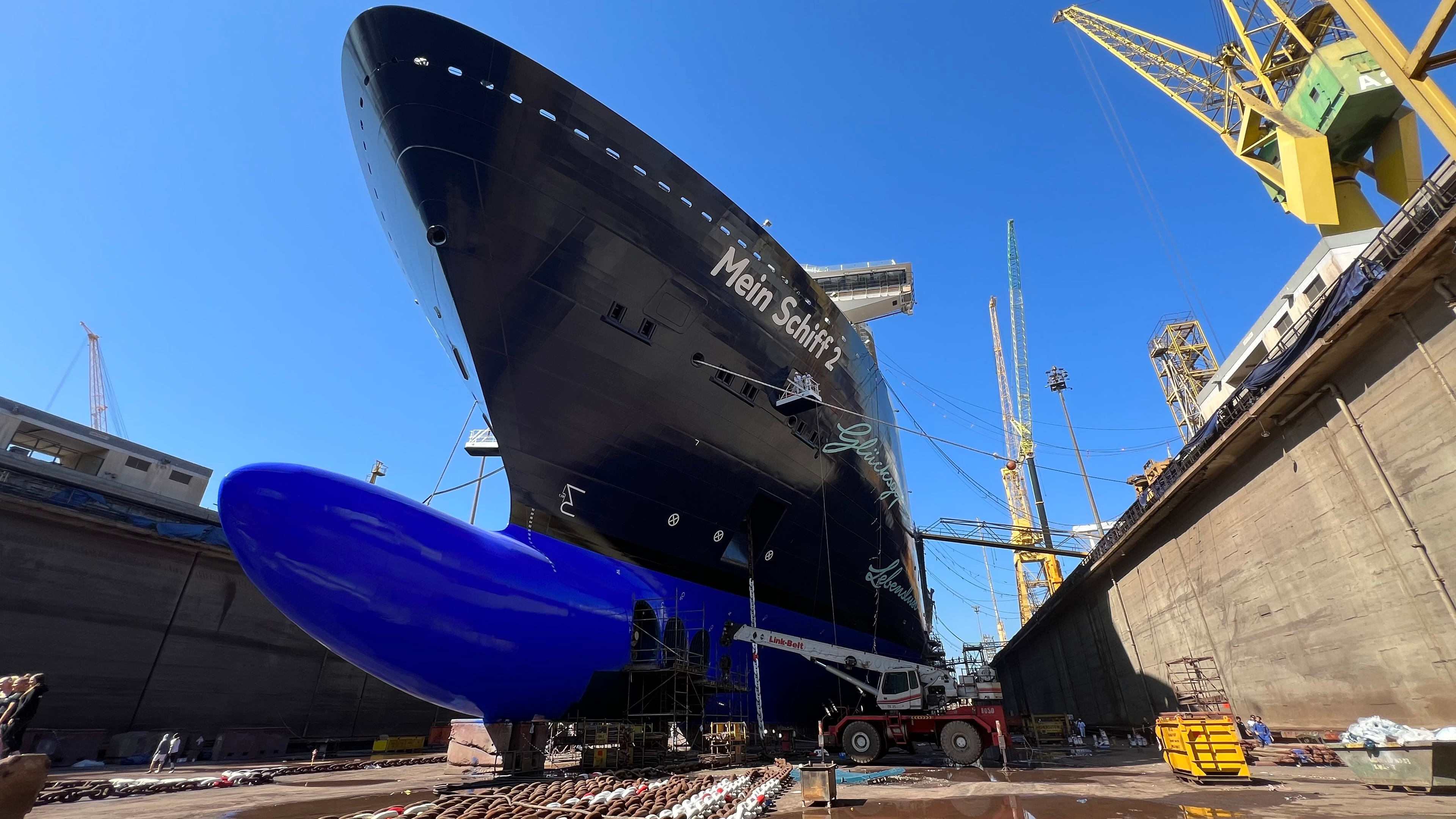 Kreuzfahrtschiff der Mein Schiff® Flotte im Trockendock, blauer Himmel.