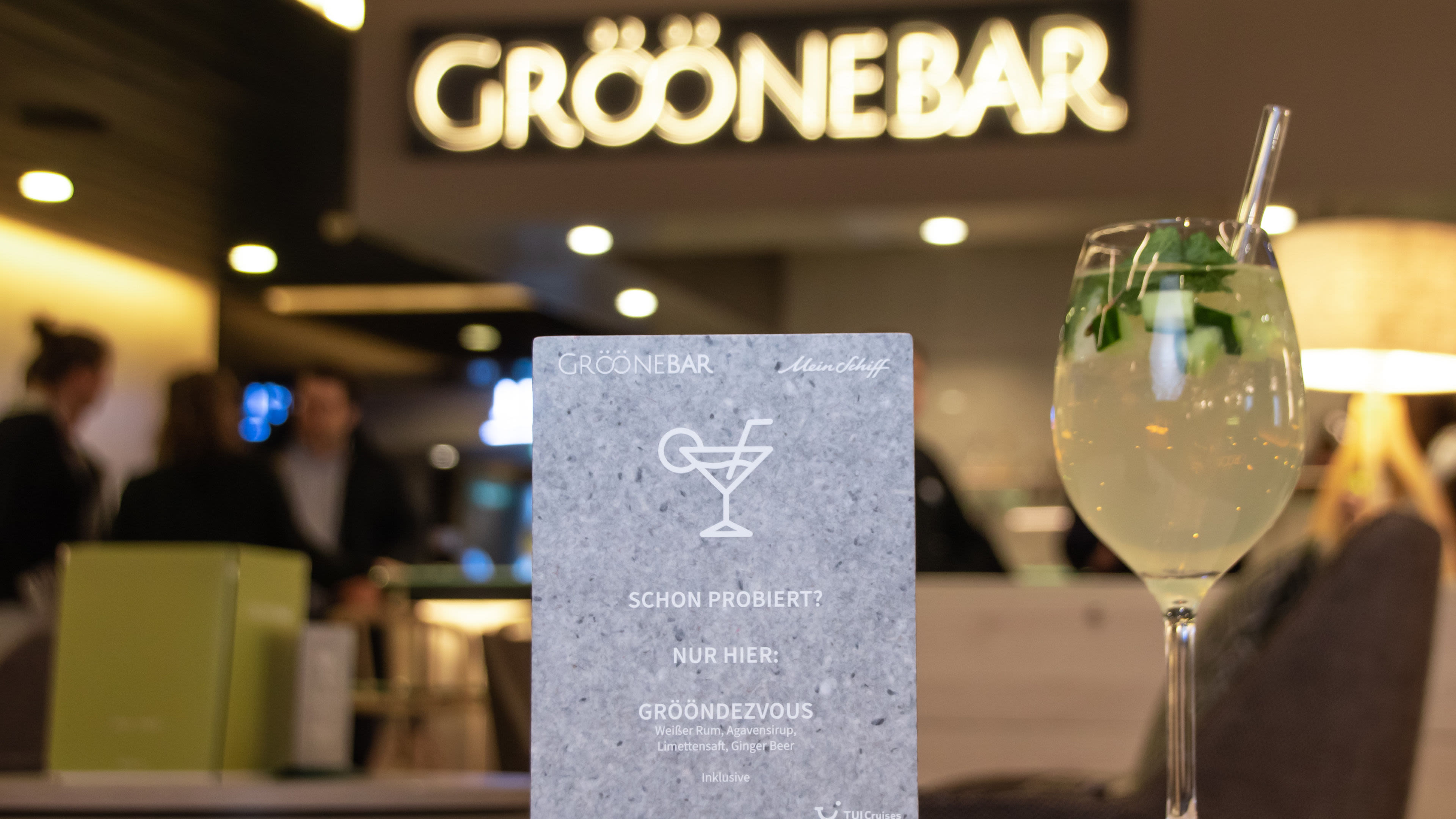 Grööne Bar Cocktail mit Cocktail Karte Grööne Bar Schild und Cocktailglas, unscharfer Hintergrund.