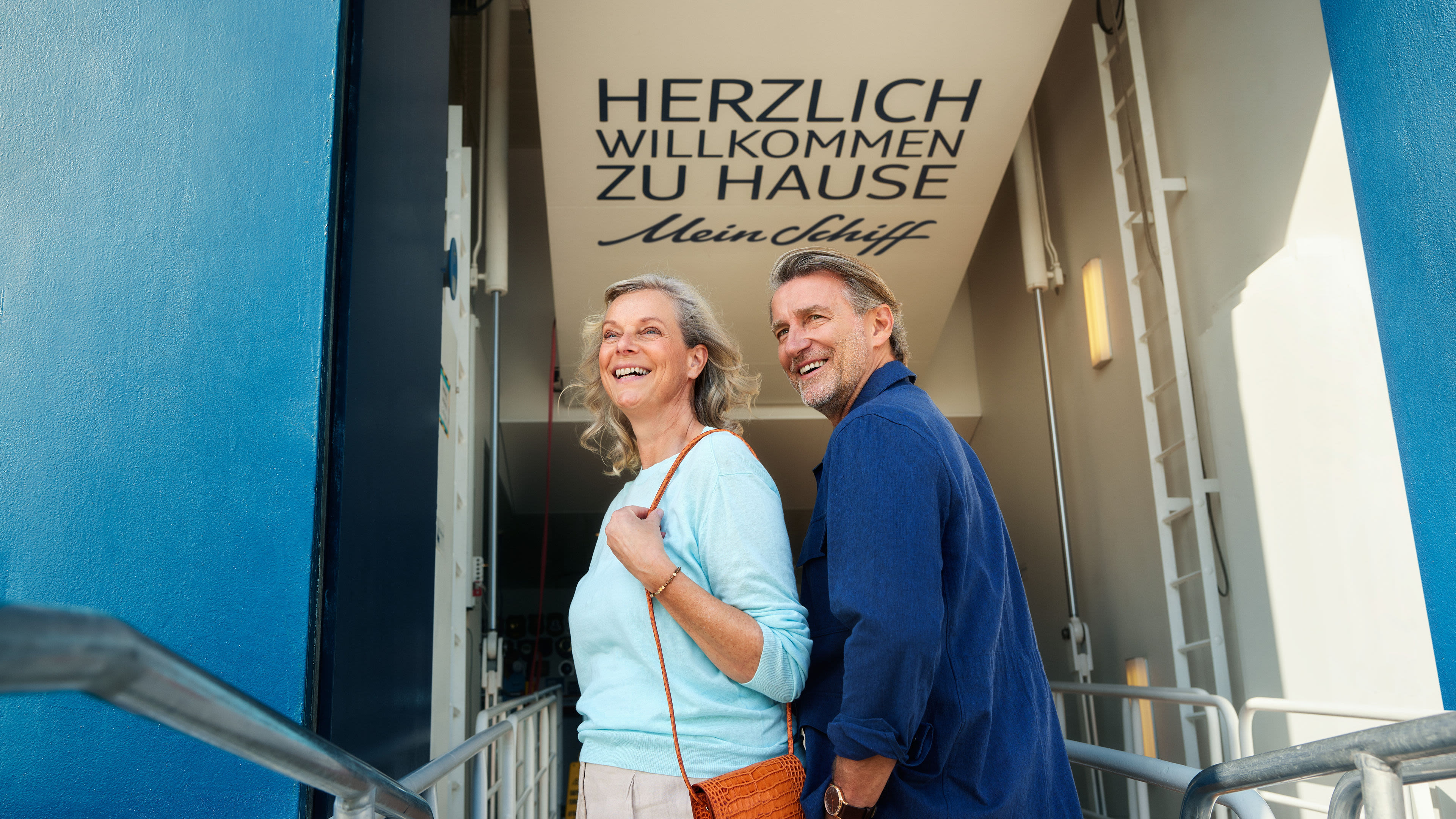Willkommen an Board Lächelndes Paar betritt Kreuzfahrtschiff der Mein Schiff® Flotte.