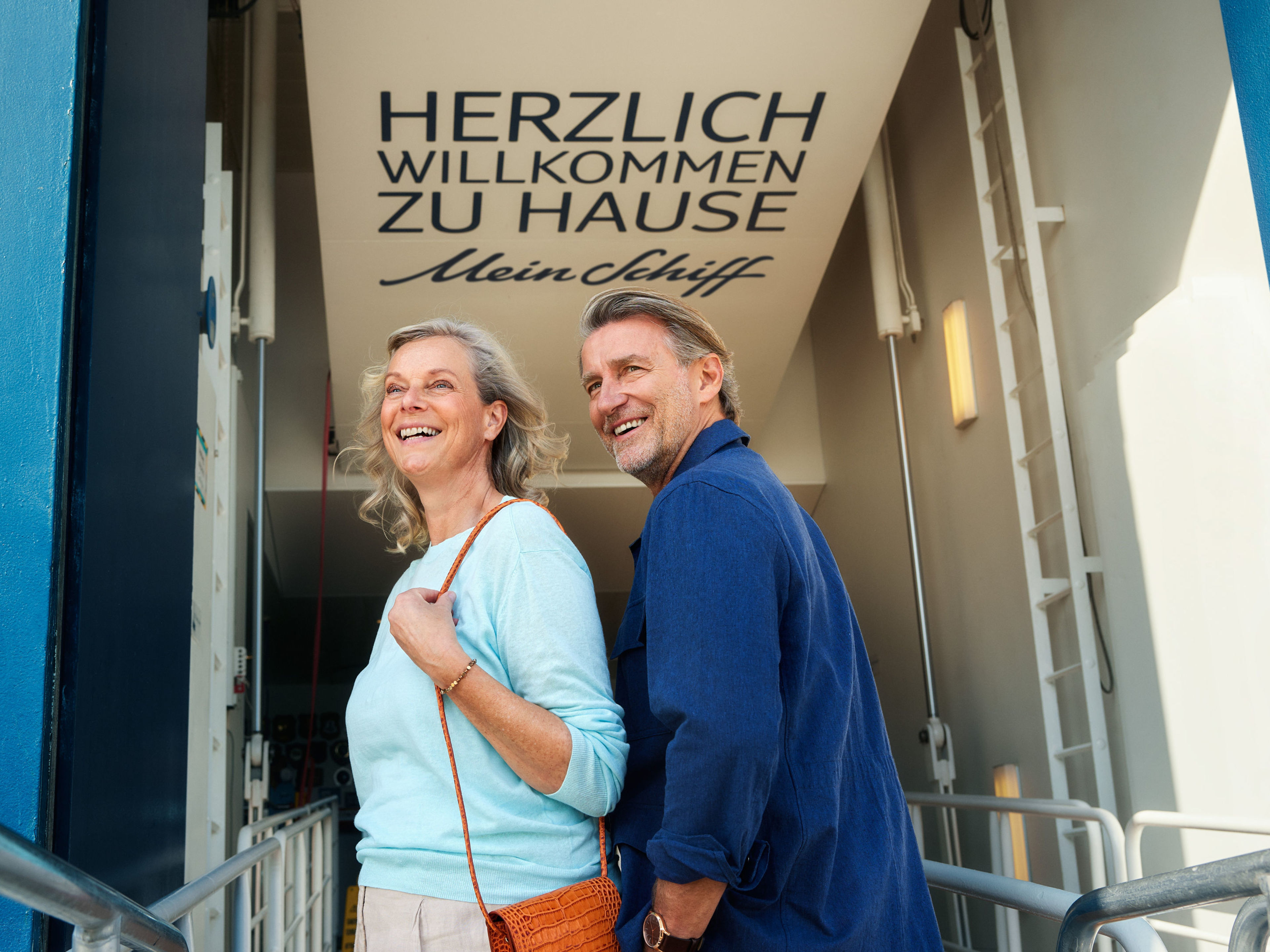 Willkommen an Board Lächelndes Paar betritt Kreuzfahrtschiff der Mein Schiff® Flotte.
