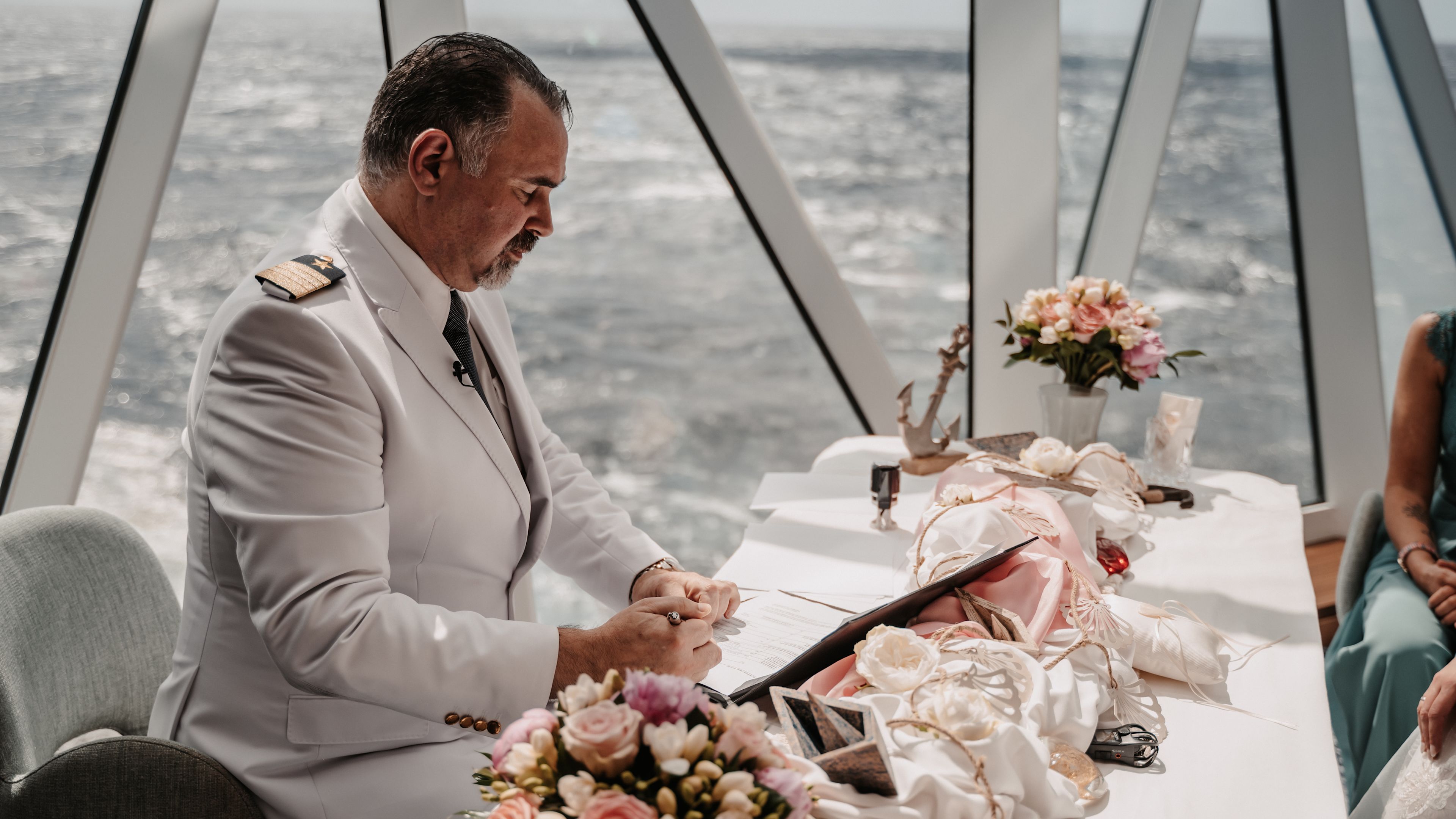 Kapitän in weißer Uniform bei Hochzeit auf Kreuzfahrtschiff, Blumenarrangement. Kapitän in weißer Uniform bei Hochzeit auf Kreuzfahrtschiff, Blumenarrangement.