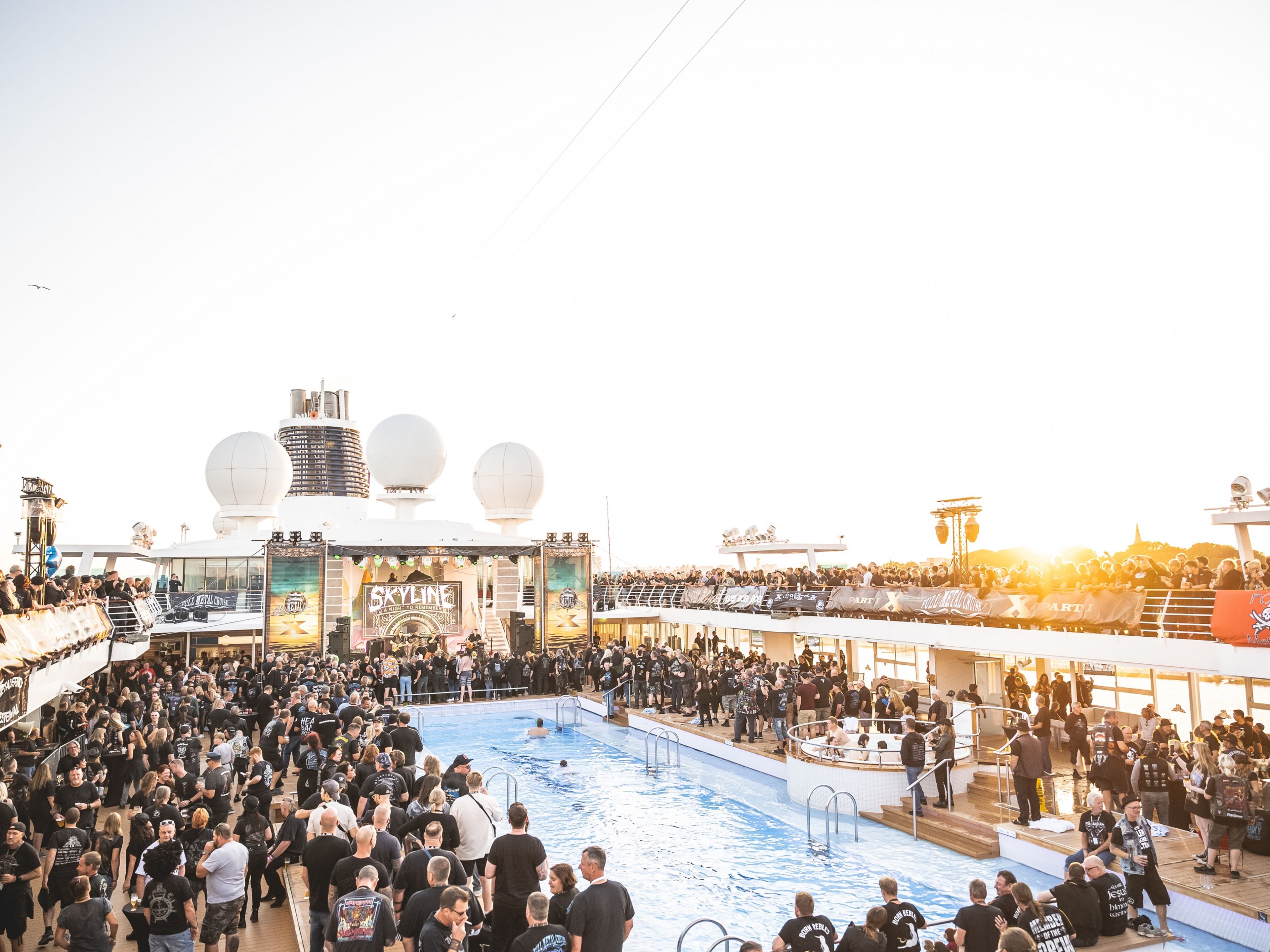 Full Metal Cruise Menschenmenge bei Sonnenuntergang auf Kreuzfahrtschiff der Mein Schiff® Flotte, Pooldeck, Konzertbühne.