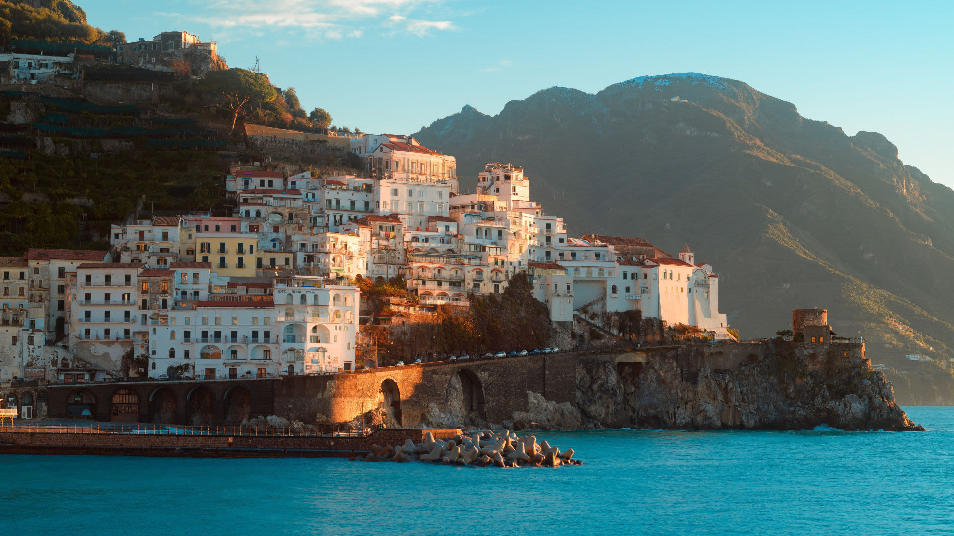 Küstenstadt Amalfi bei Sonnenuntergang, bunte Häuser, blaues Meer.