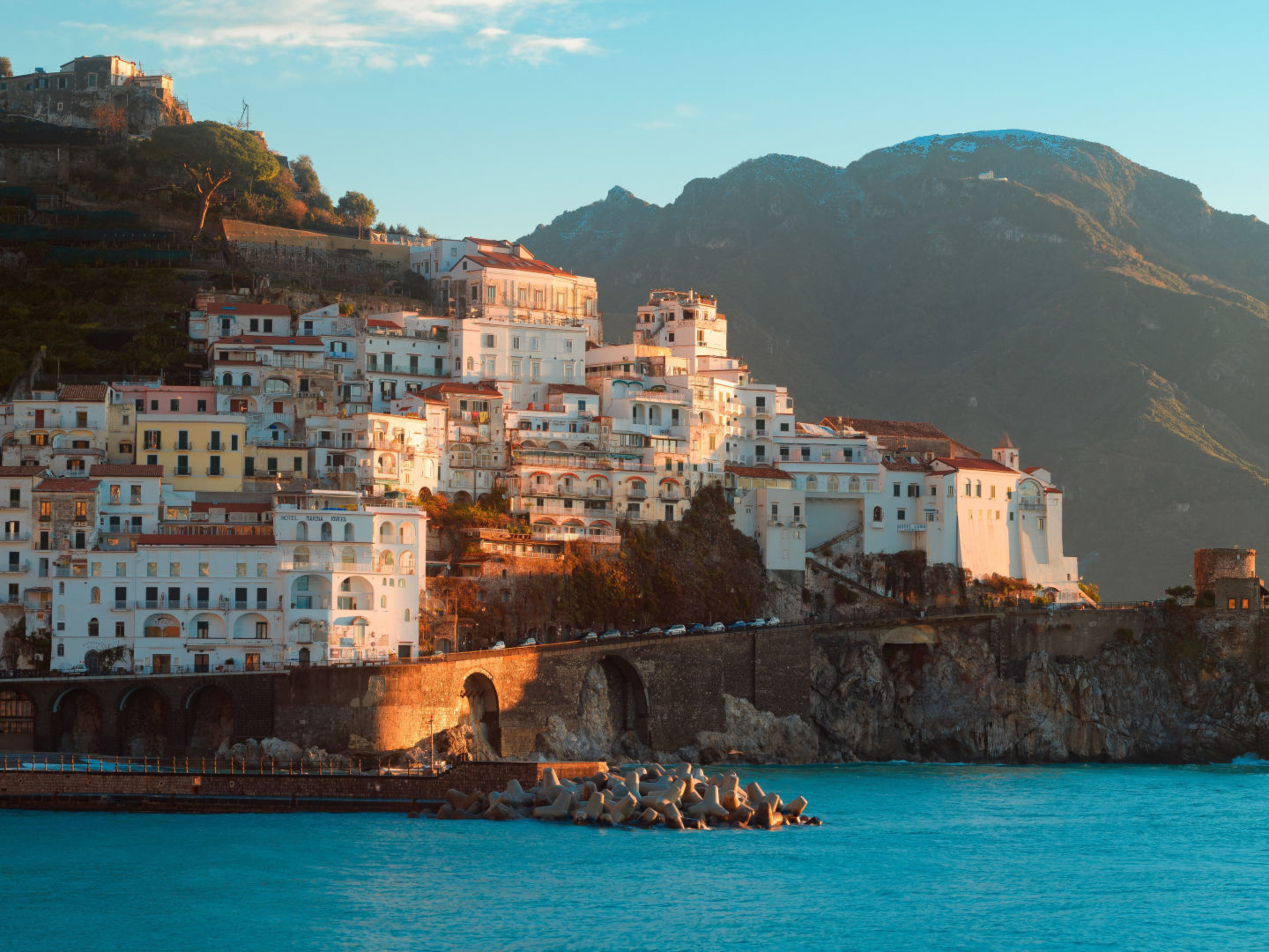 Amalfi Italien Küstenstadt Amalfi bei Sonnenuntergang, bunte Häuser, blaues Meer.