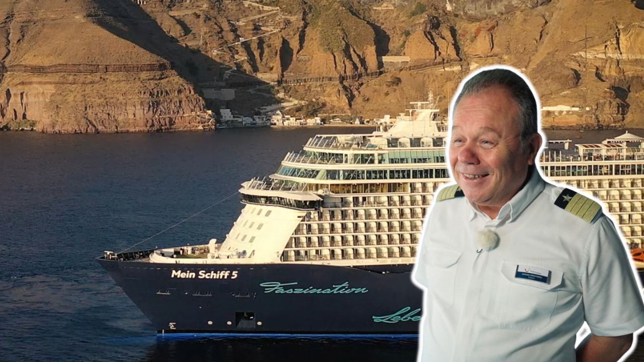 Kapitän vor Kreuzfahrtschiff der Mein Schiff® Flotte, Küste im Hintergrund.