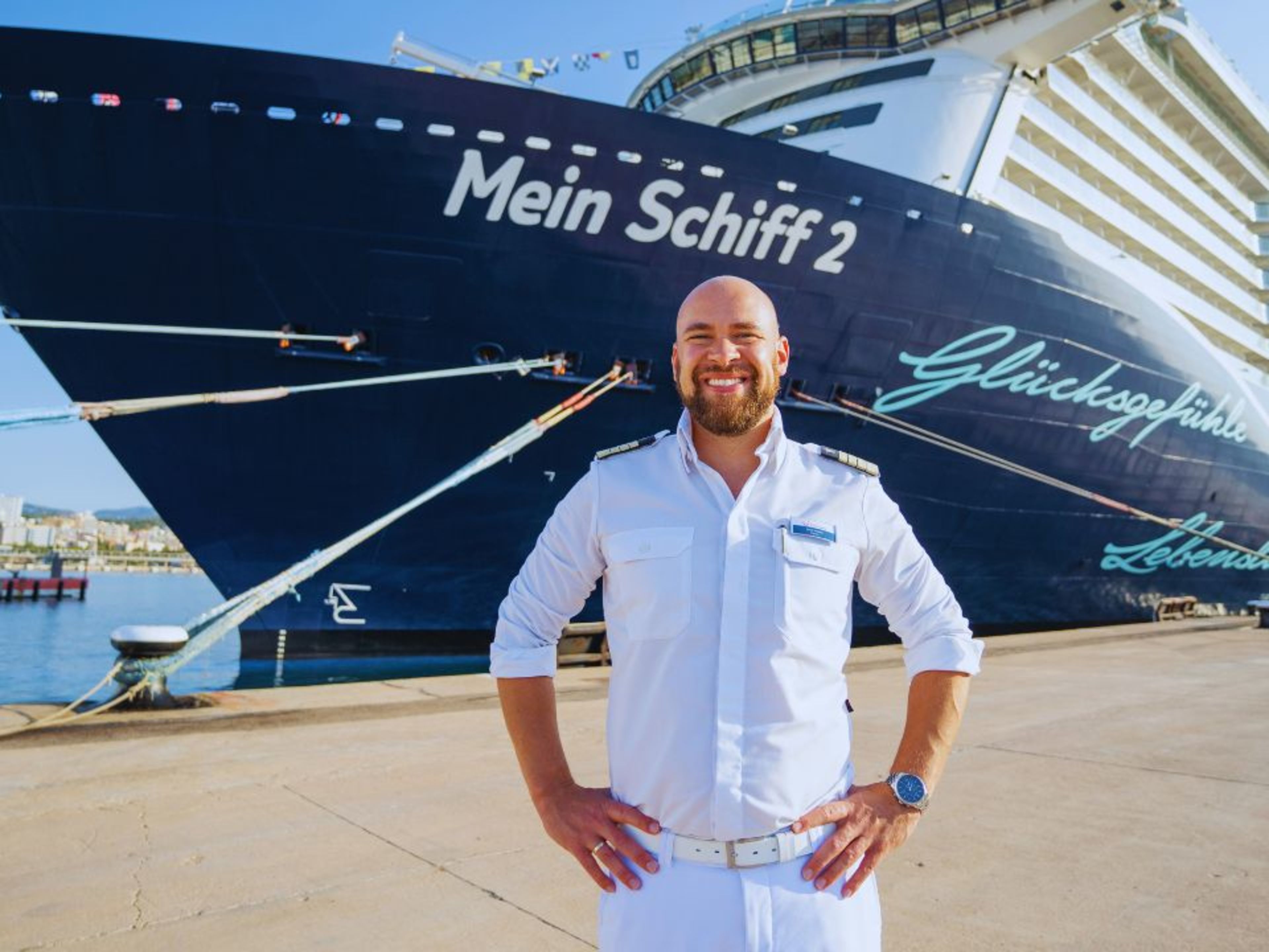 Mann in Uniform vor Kreuzfahrtschiff der Mein Schiff® Flotte im Hafen. Mann in Uniform vor Kreuzfahrtschiff der Mein Schiff® Flotte im Hafen.