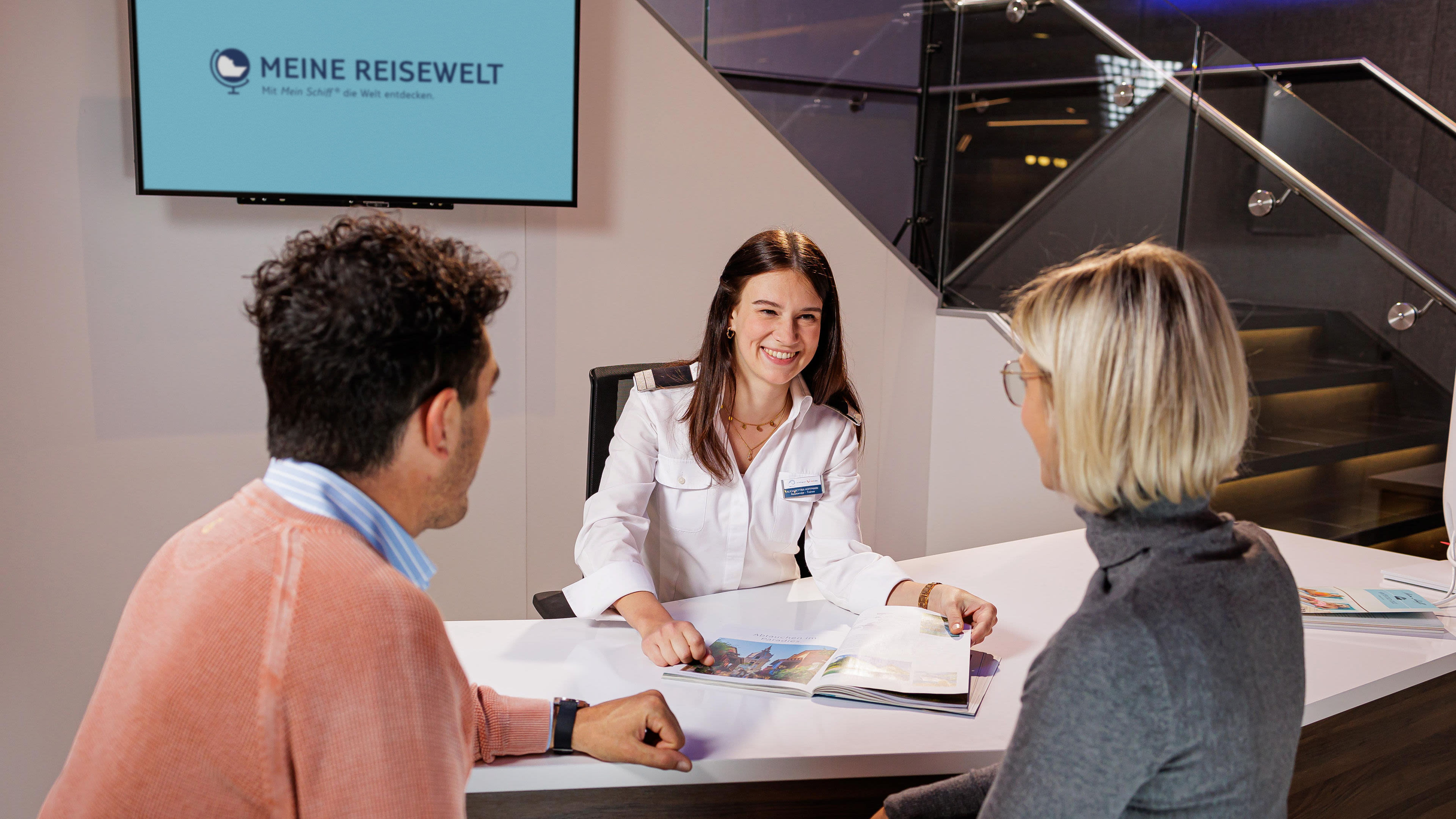 Beraterin im weißen Hemd spricht mit Paar am Tisch. Beraterin im weißen Hemd spricht mit Paar am Tisch.