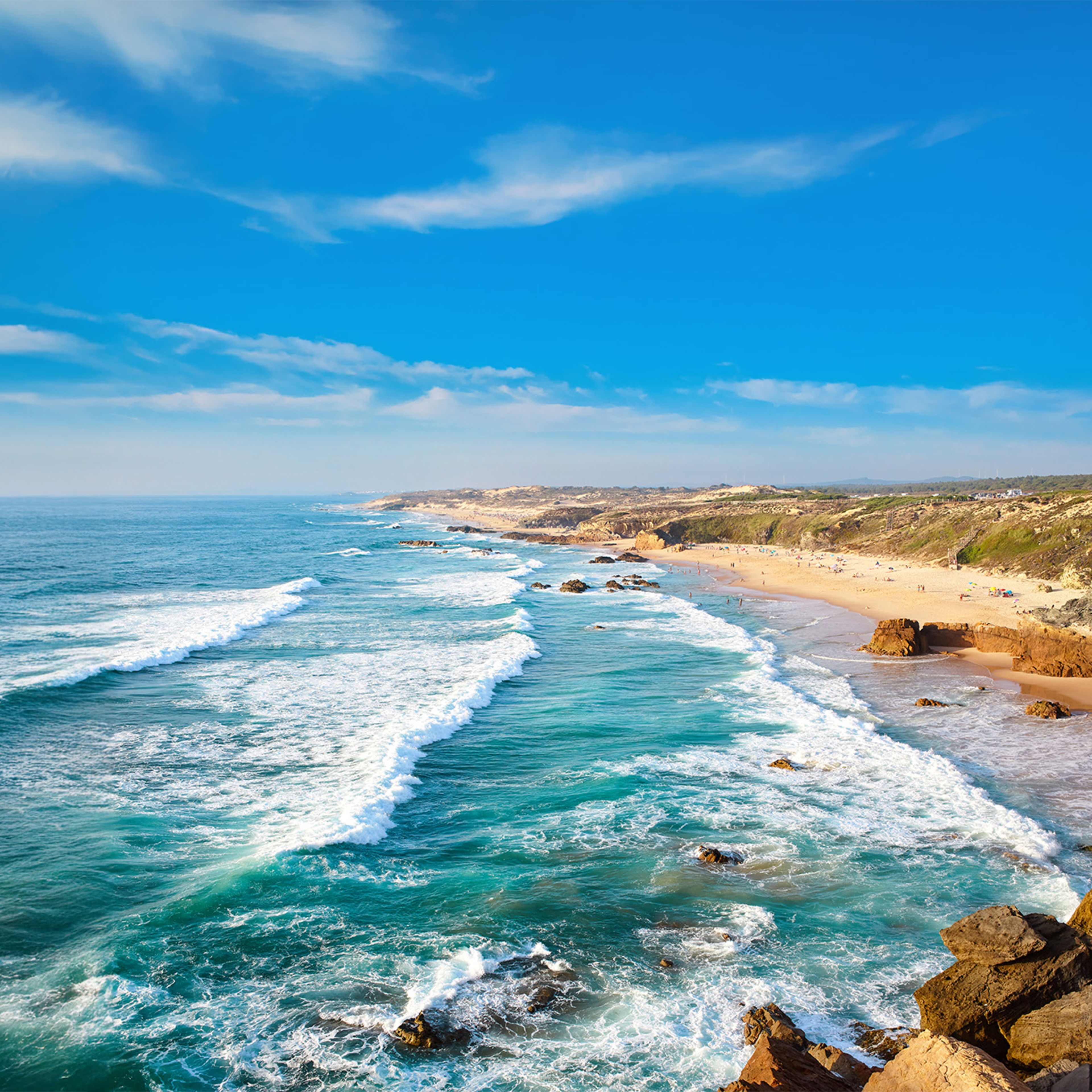 Atlantikküste Portugal Küste mit Wellen, blauem Himmel und Sandstrand in Portugal.