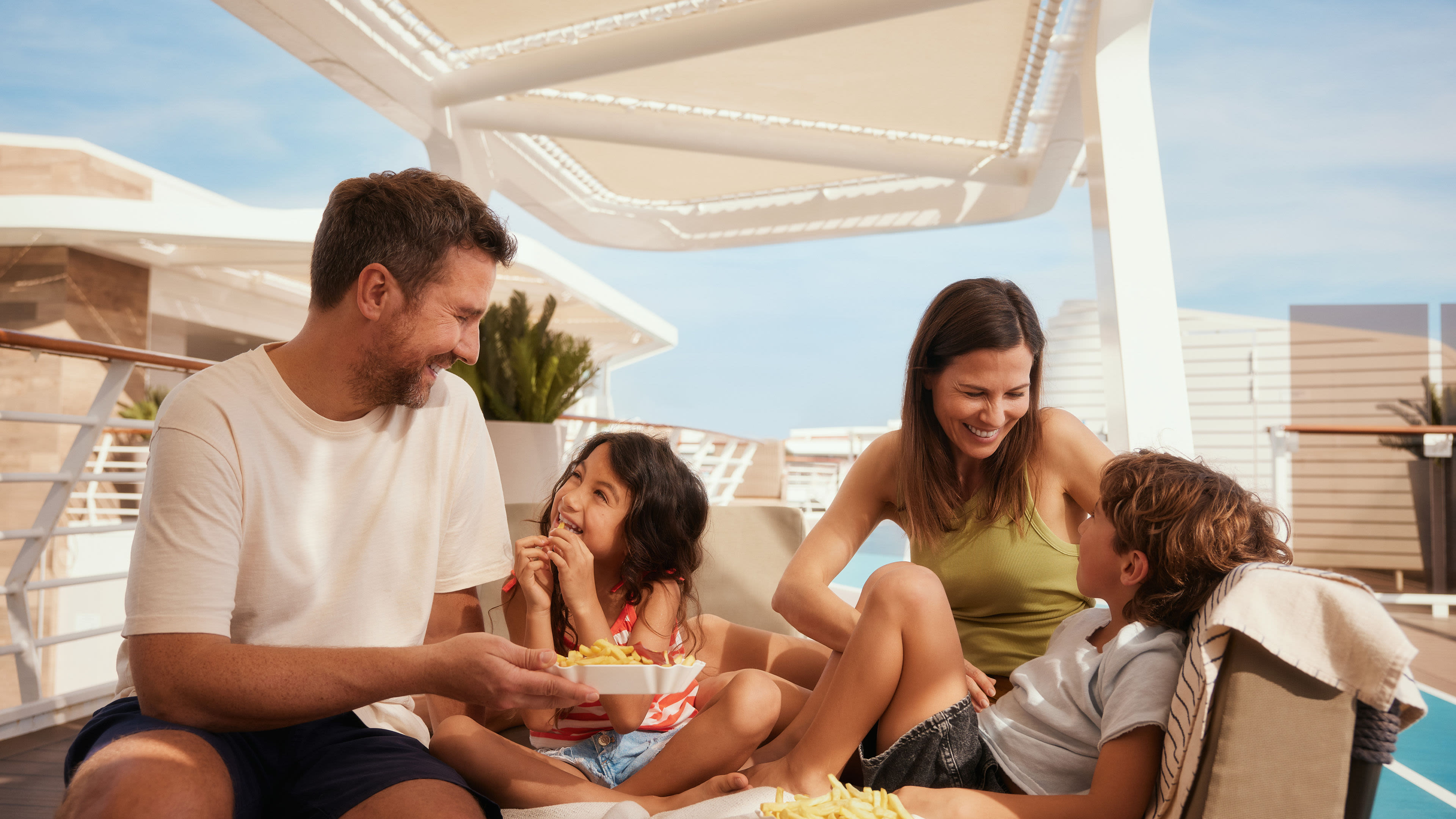 Familie genießt Pommes auf Kreuzfahrtschiff der Mein Schiff® Flotte.