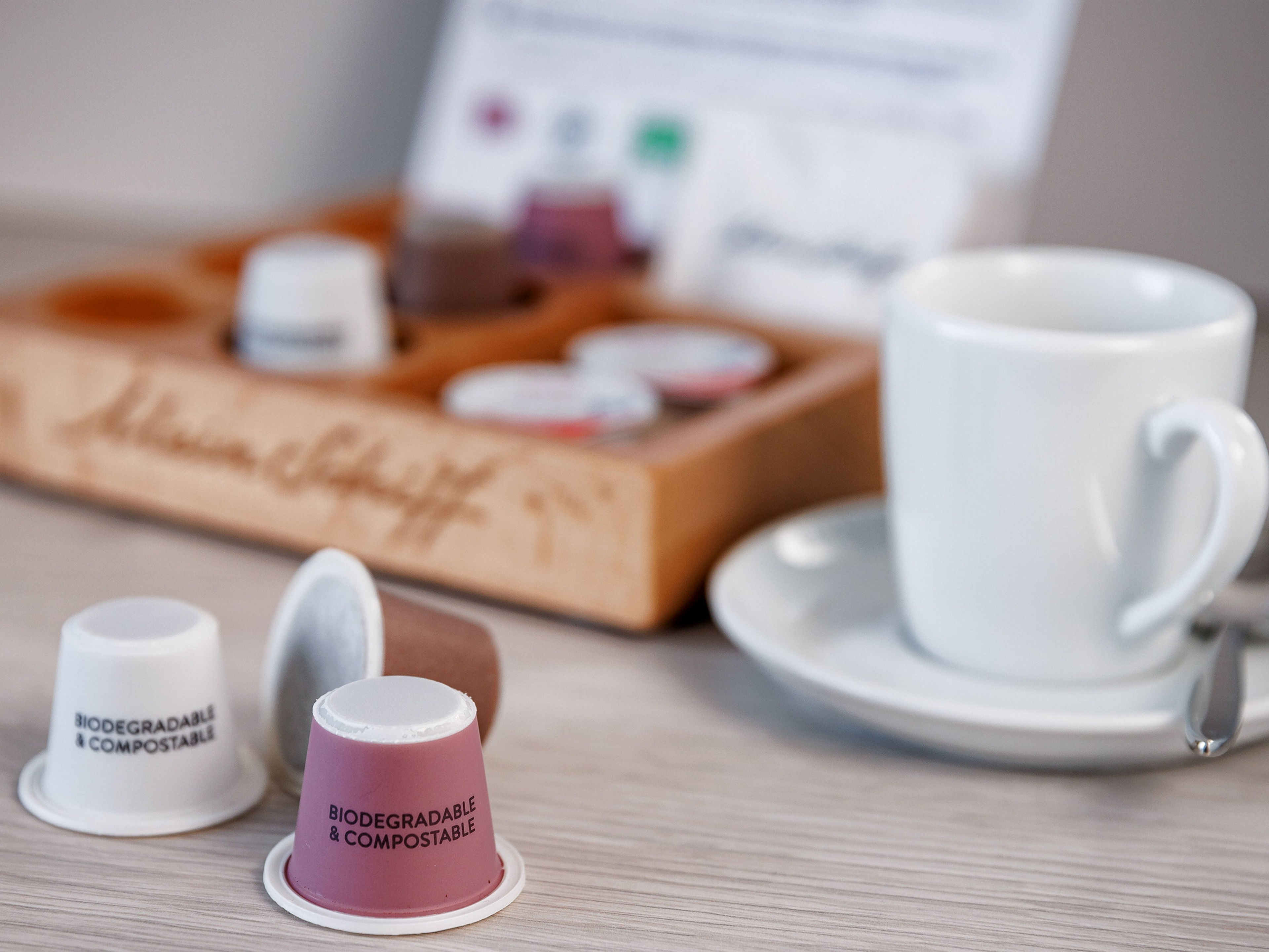 Nachhaltigkeit - Kaffekapseln Faircaps Biologisch abbaubare Kaffeekapseln und weiße Tasse auf Tisch.