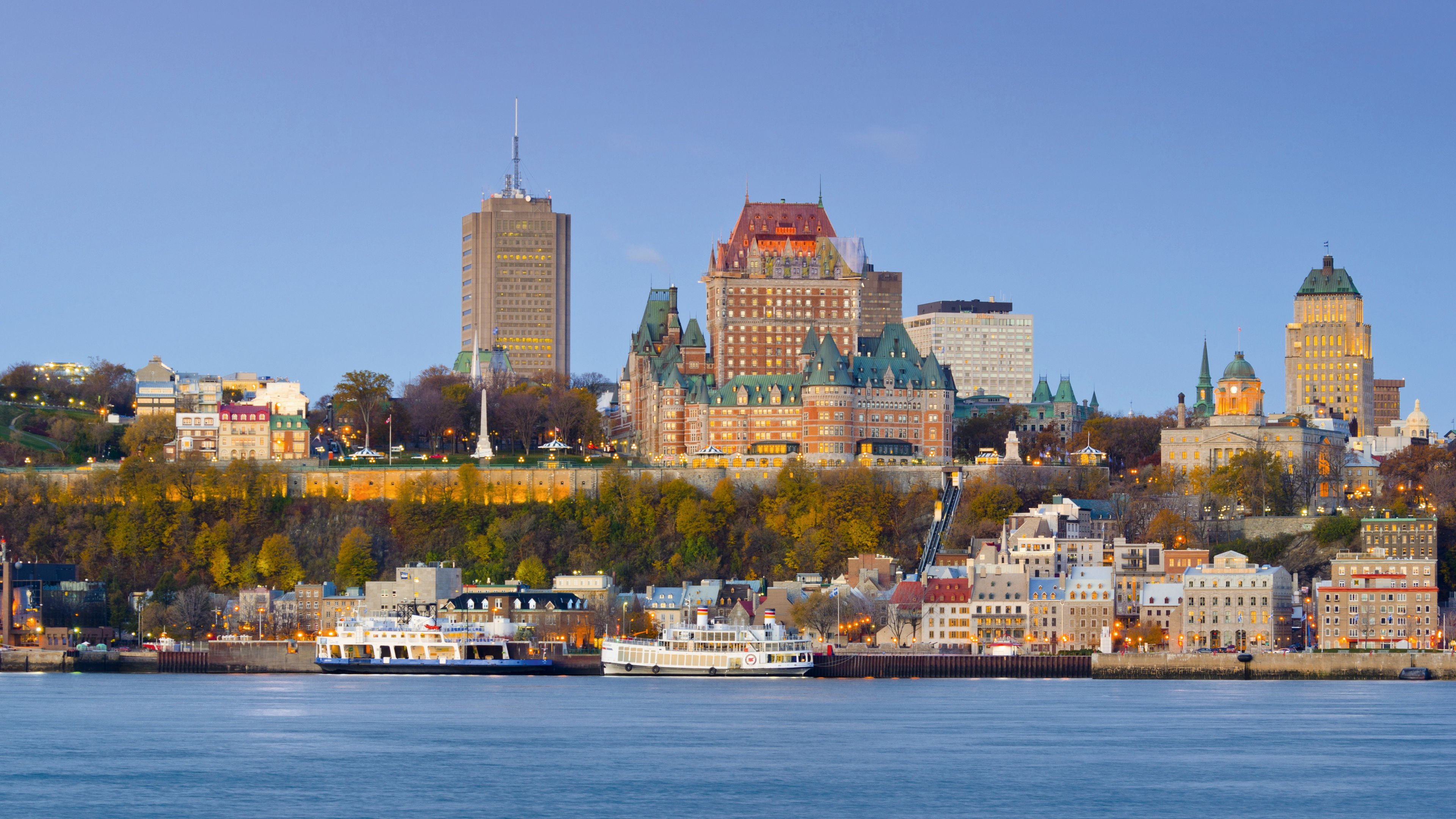 Quebec City Skyline mit Château Frontenac bei Sonnenuntergang, blauer Himmel.