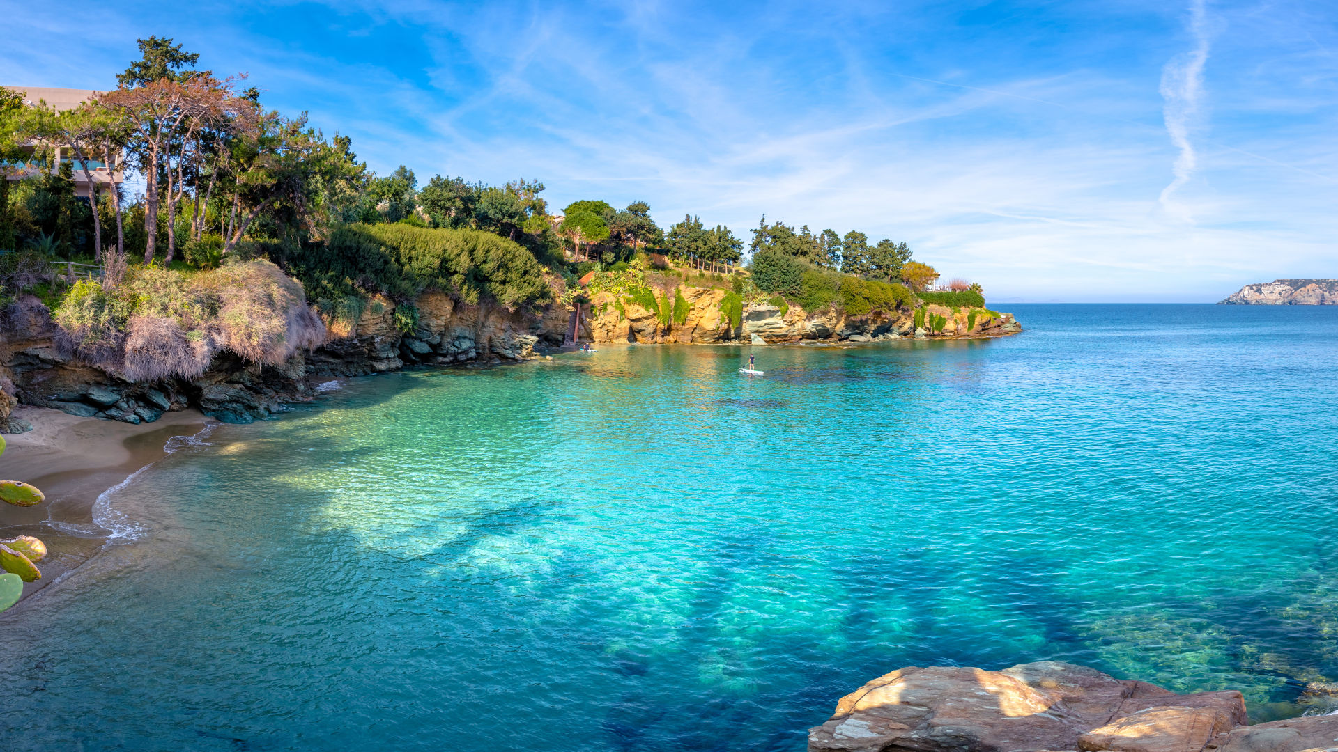 Kleine Bucht mit türkisfarbenem Wasser und grünen Klippen.