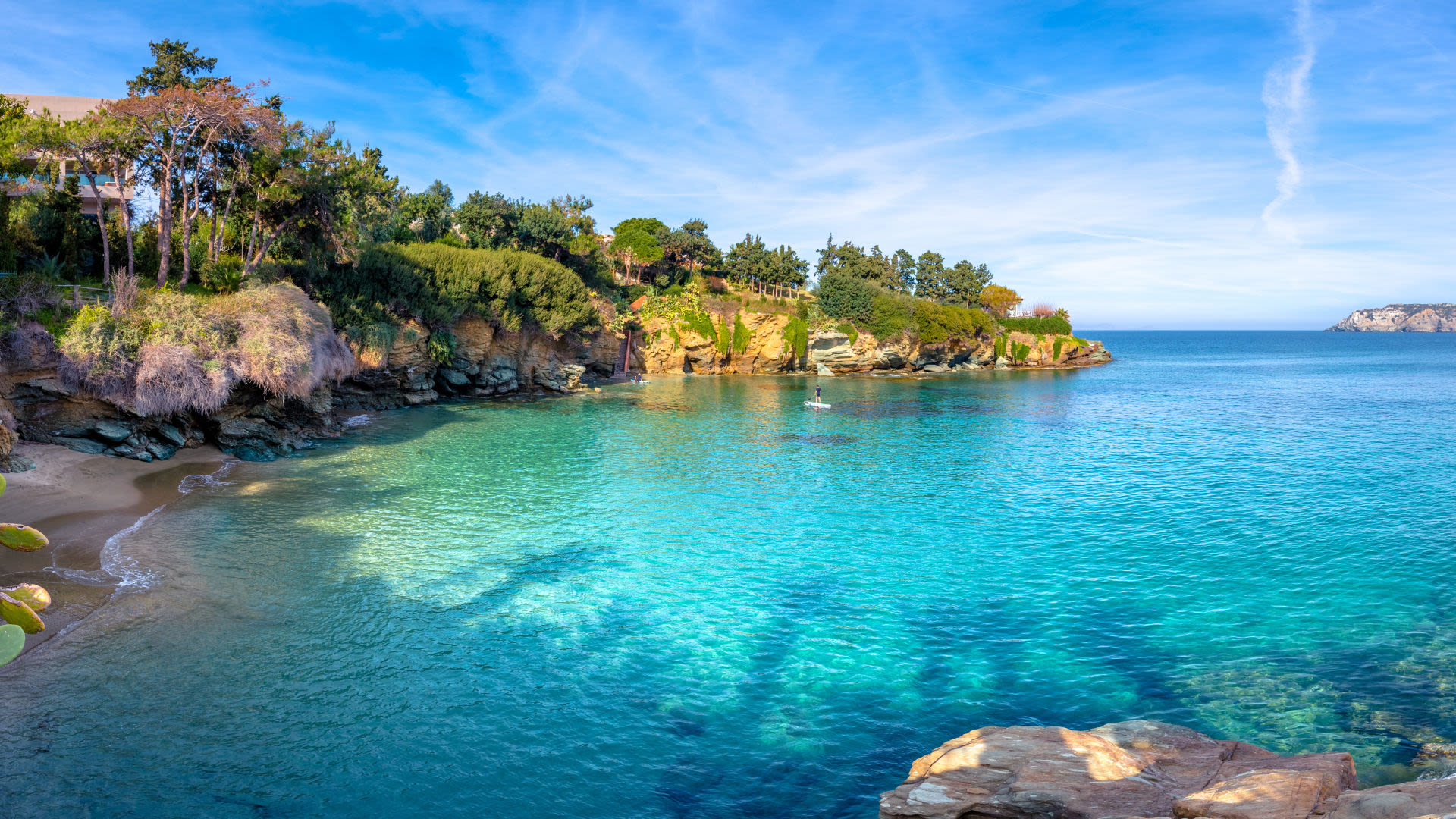 Kleine Bucht mit türkisfarbenem Wasser und grünen Klippen.