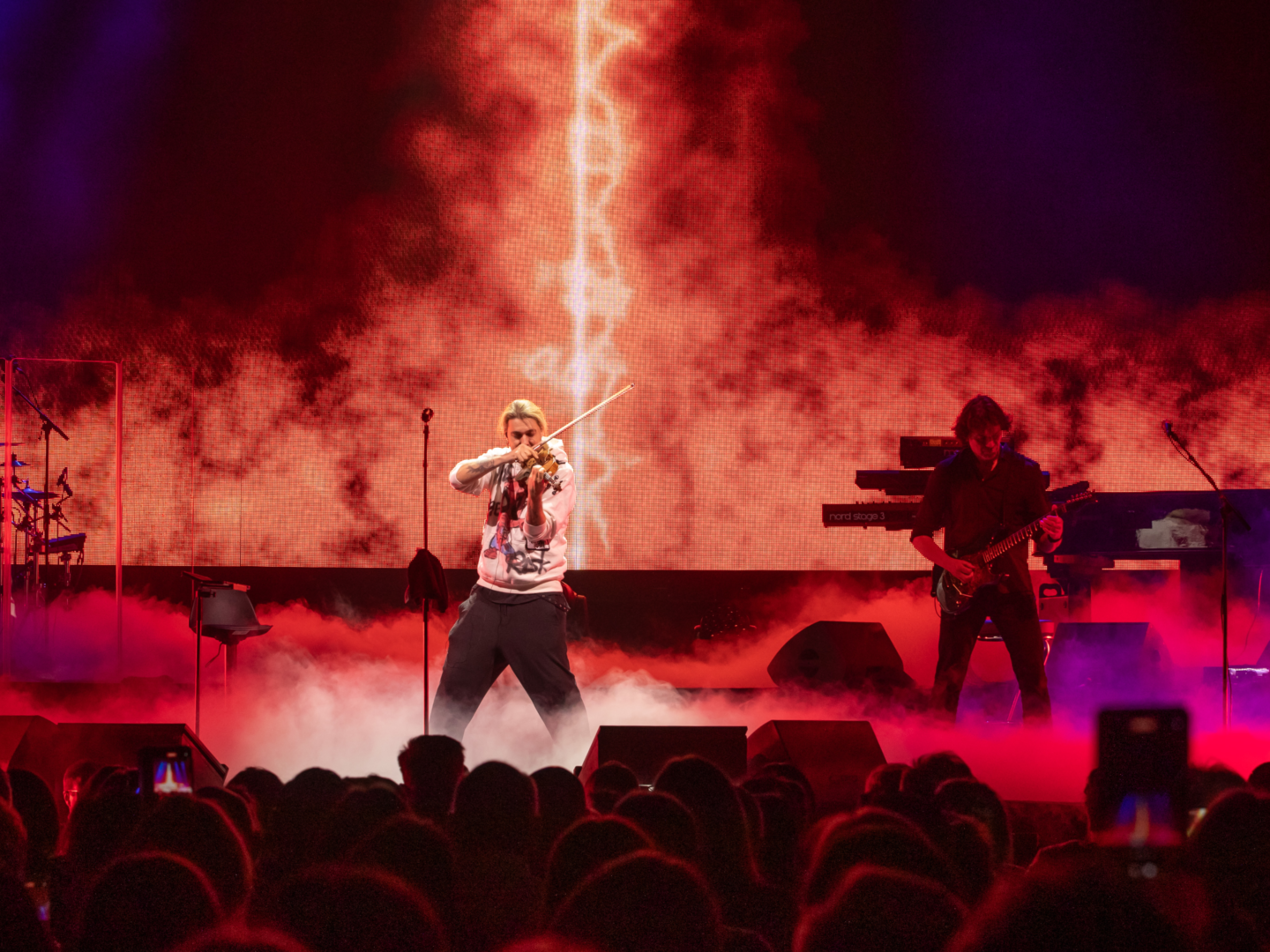 David Garrett Geiger und Gitarrist auf Bühne mit rotem Licht und Nebel.