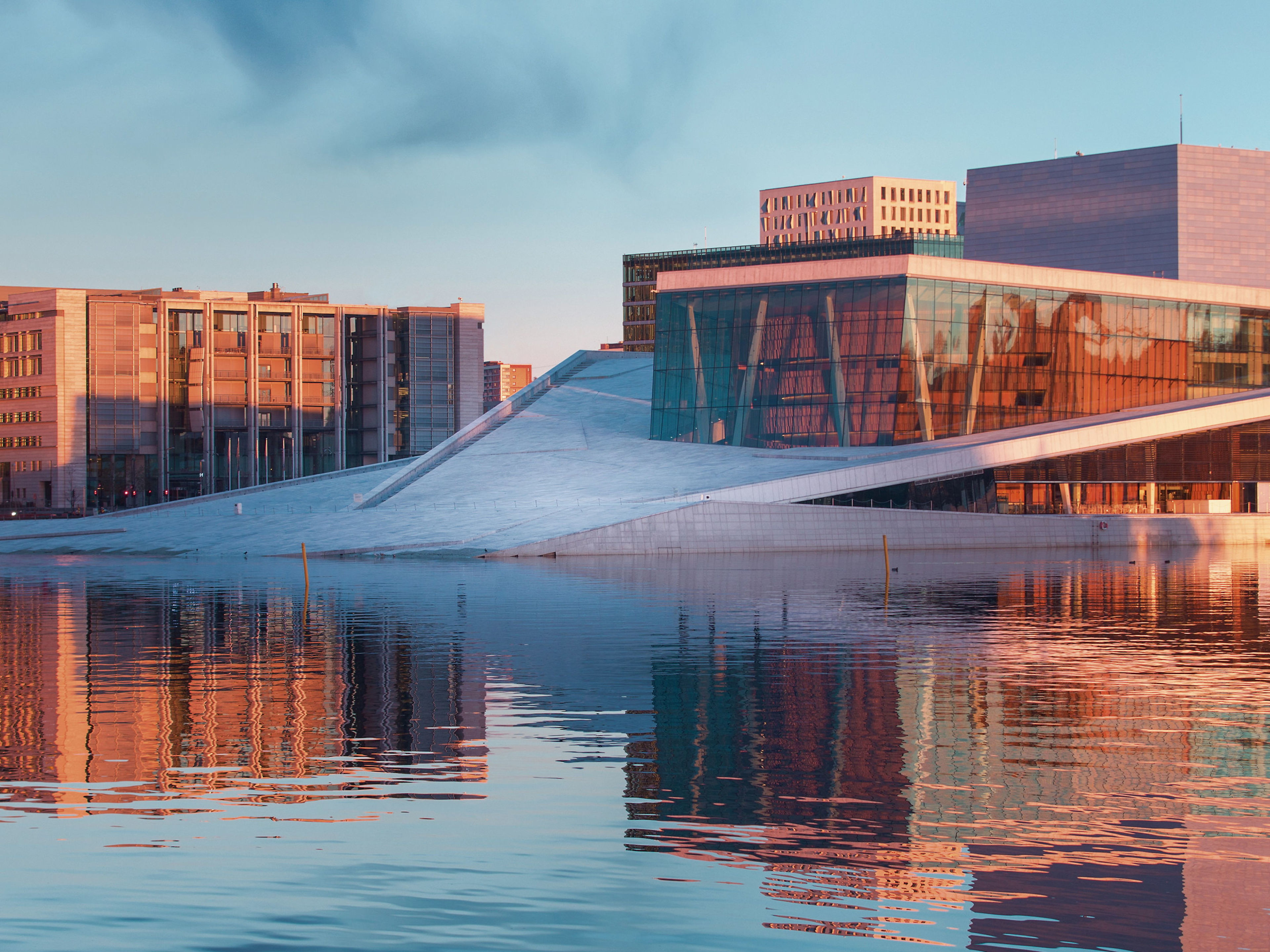 Oslo Norwegen Opernhaus Oslo bei Sonnenuntergang, reflektiert im Wasser.