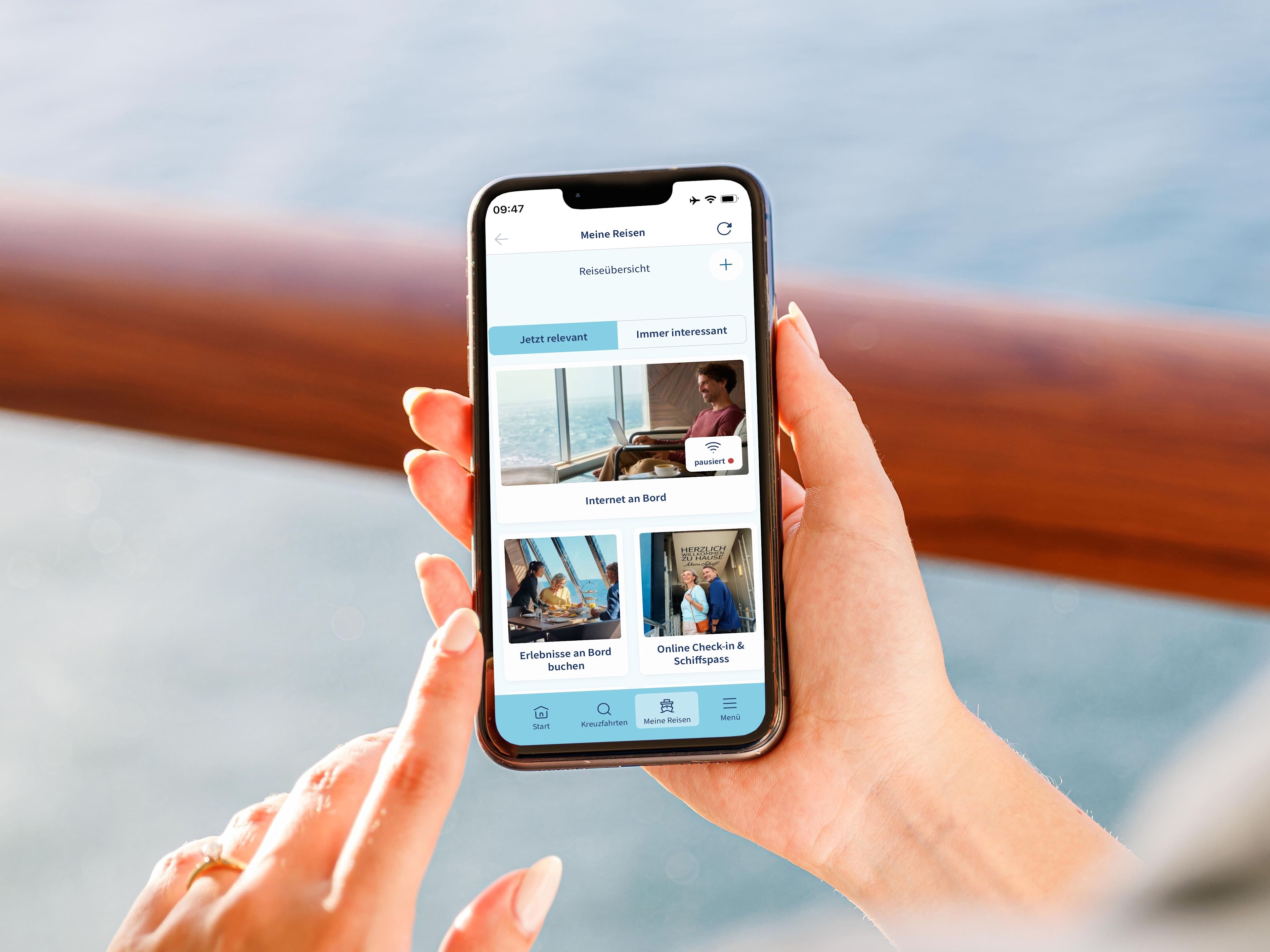 Internet Verbinden Schritt 2 Person hält Smartphone mit Kreuzfahrt-App, Meer im Hintergrund.