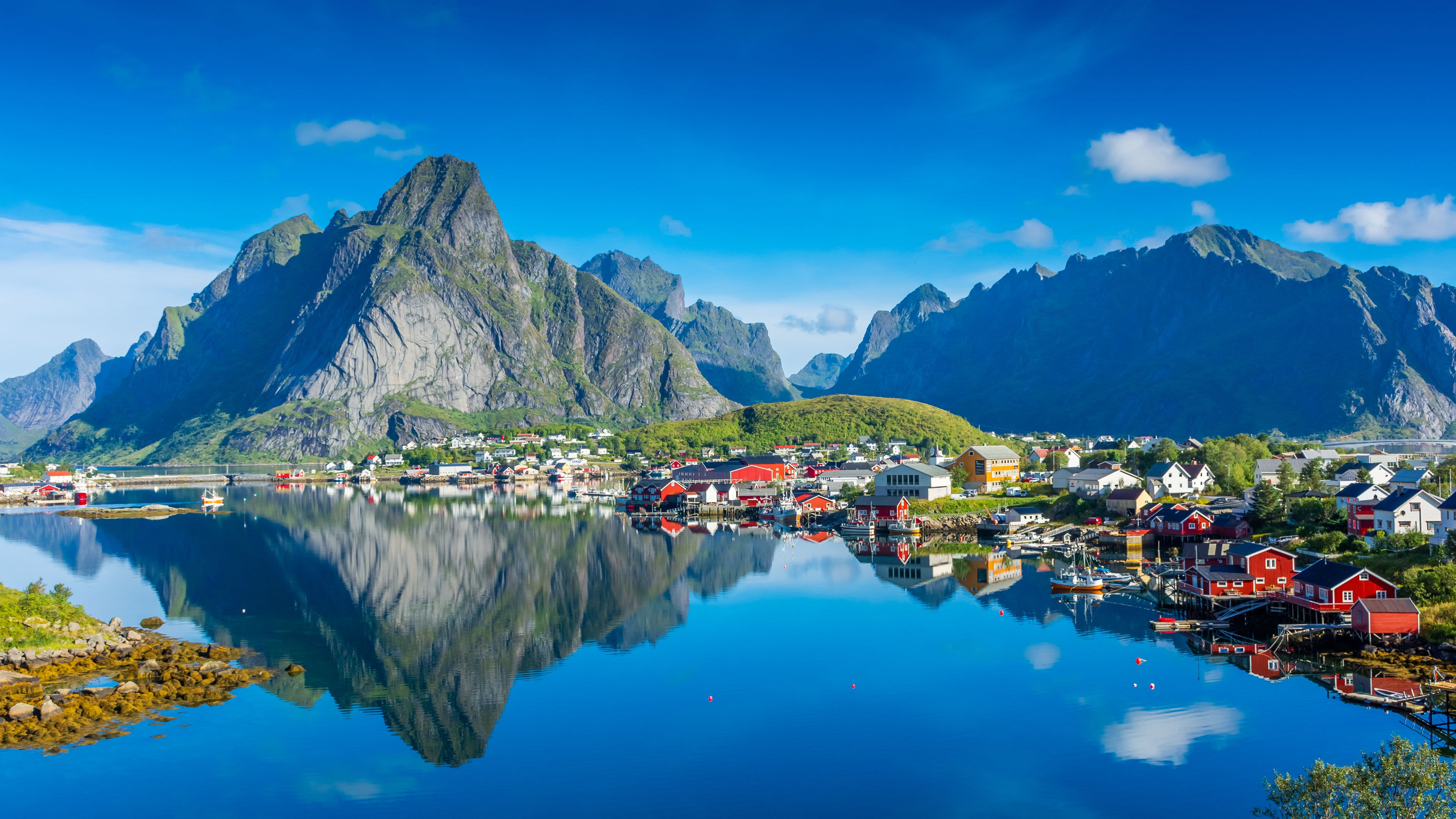 Lofoten Norwegen Nordland Bunte Häuser am Wasser vor majestätischen Bergen, Lofoten.