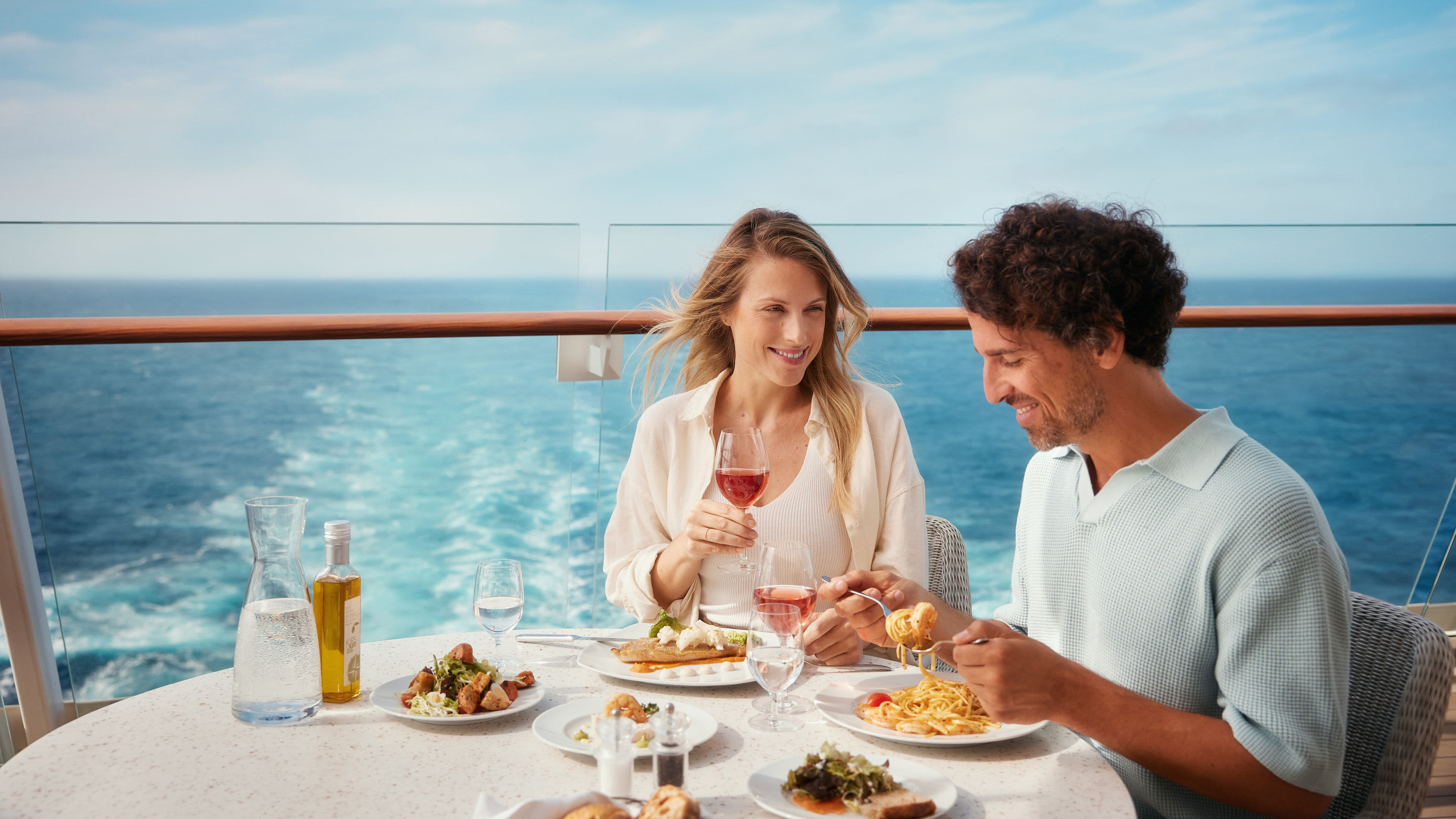 Paar genießt Mittagessen auf Kreuzfahrtschiff mit Meerblick.