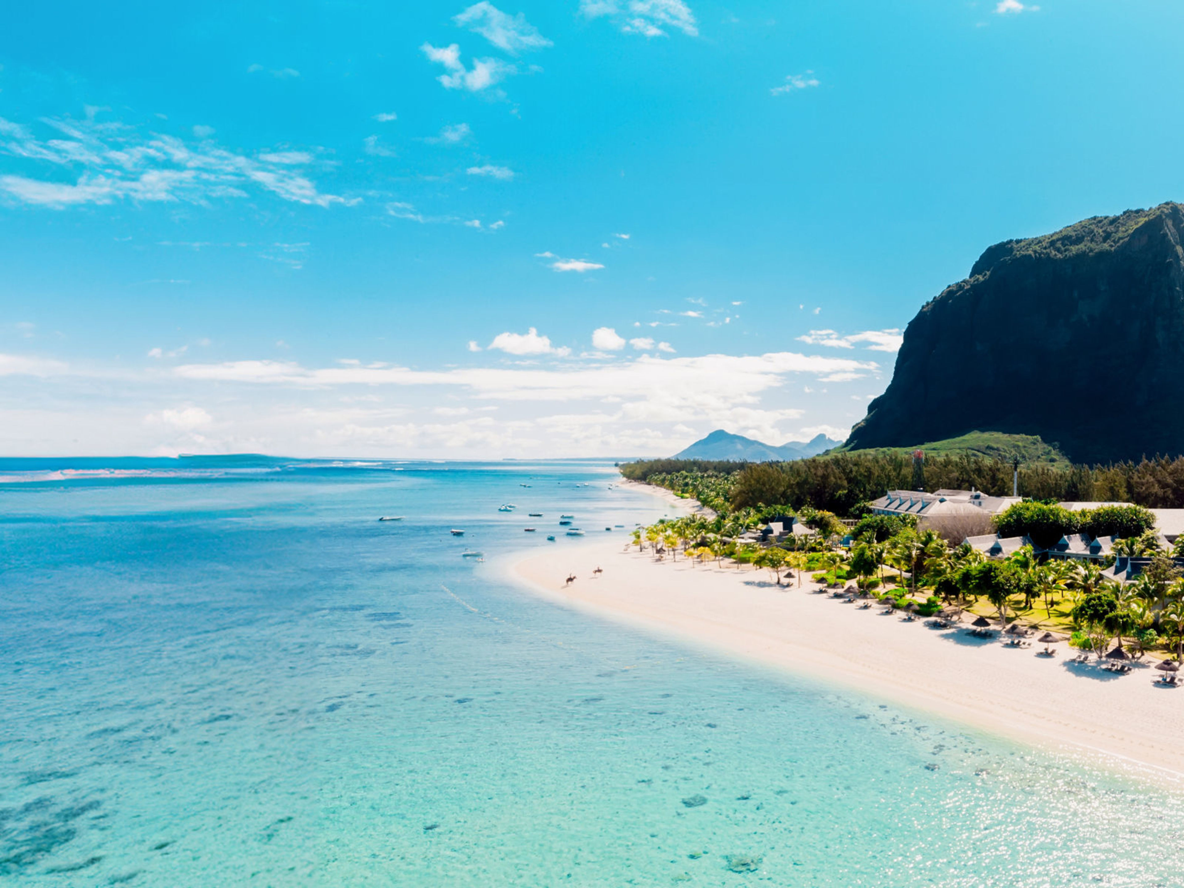 Mauritius Strand von Le Morne, Mauritius, mit tĂĽrkisfarbenem Wasser und Bergkulisse.