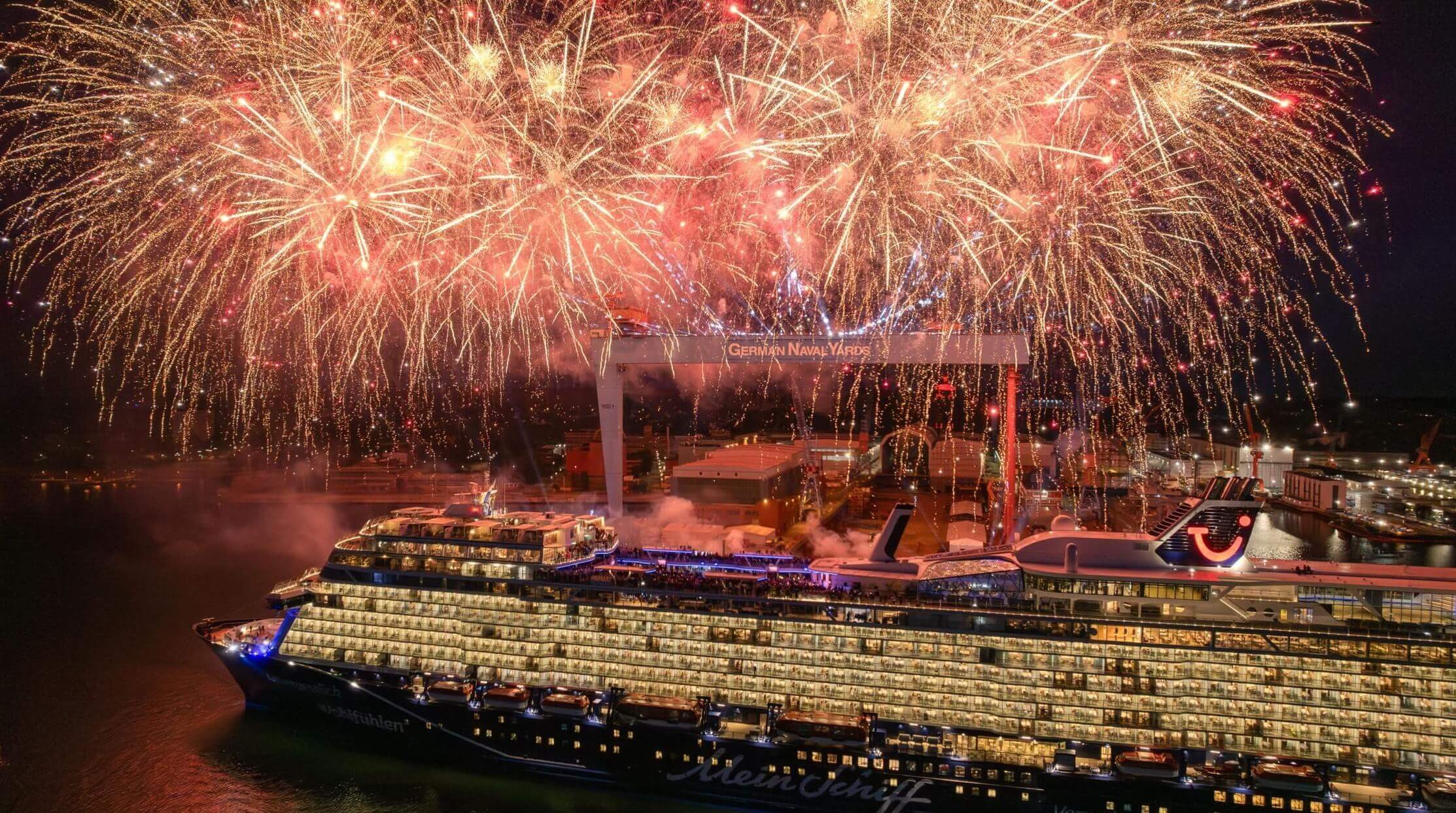 Kreuzfahrtschiff der Mein Schiff® Flotte mit Feuerwerk im Hafen.