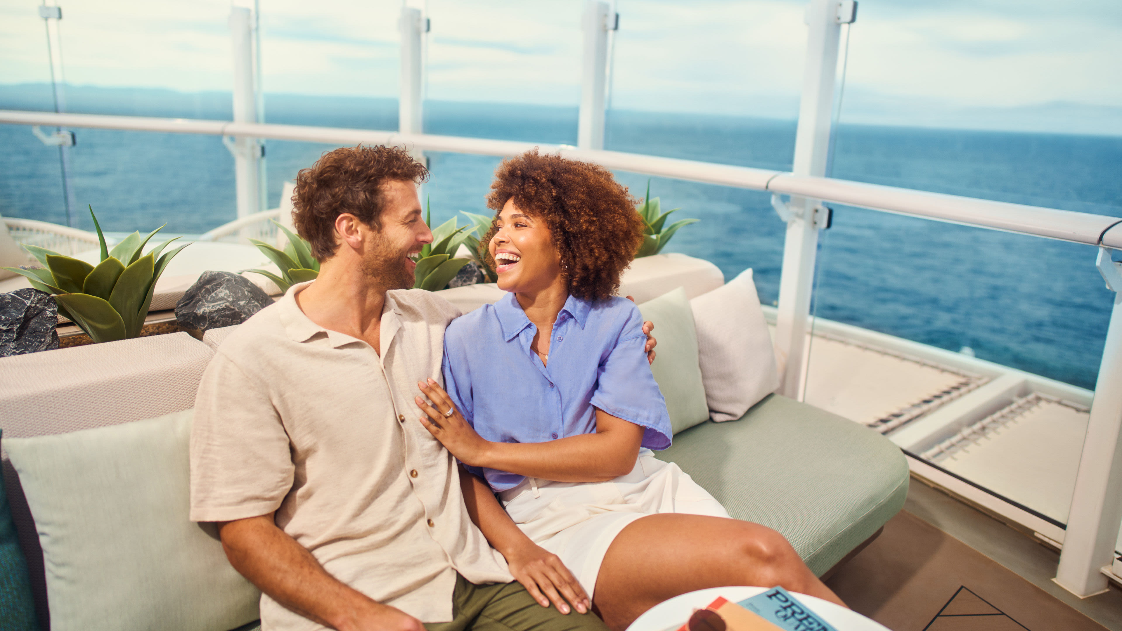 Paar lacht auf Kreuzfahrtschiff der Mein Schiff® Flotte, Meerblick.