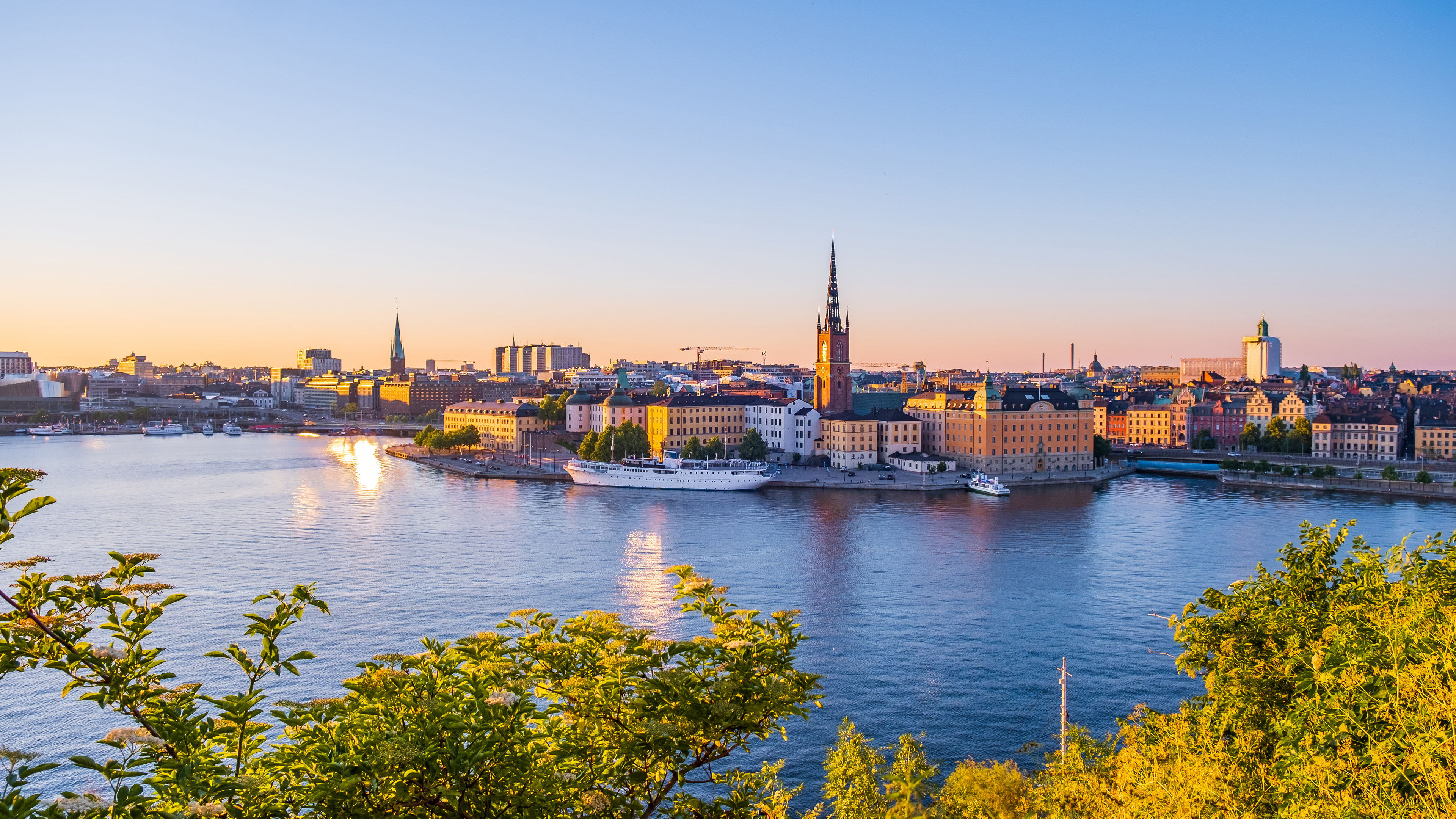 Stockholm Schweden Stockholm bei Sonnenuntergang, Wasser, Gebäude, Kirche, blauer Himmel.